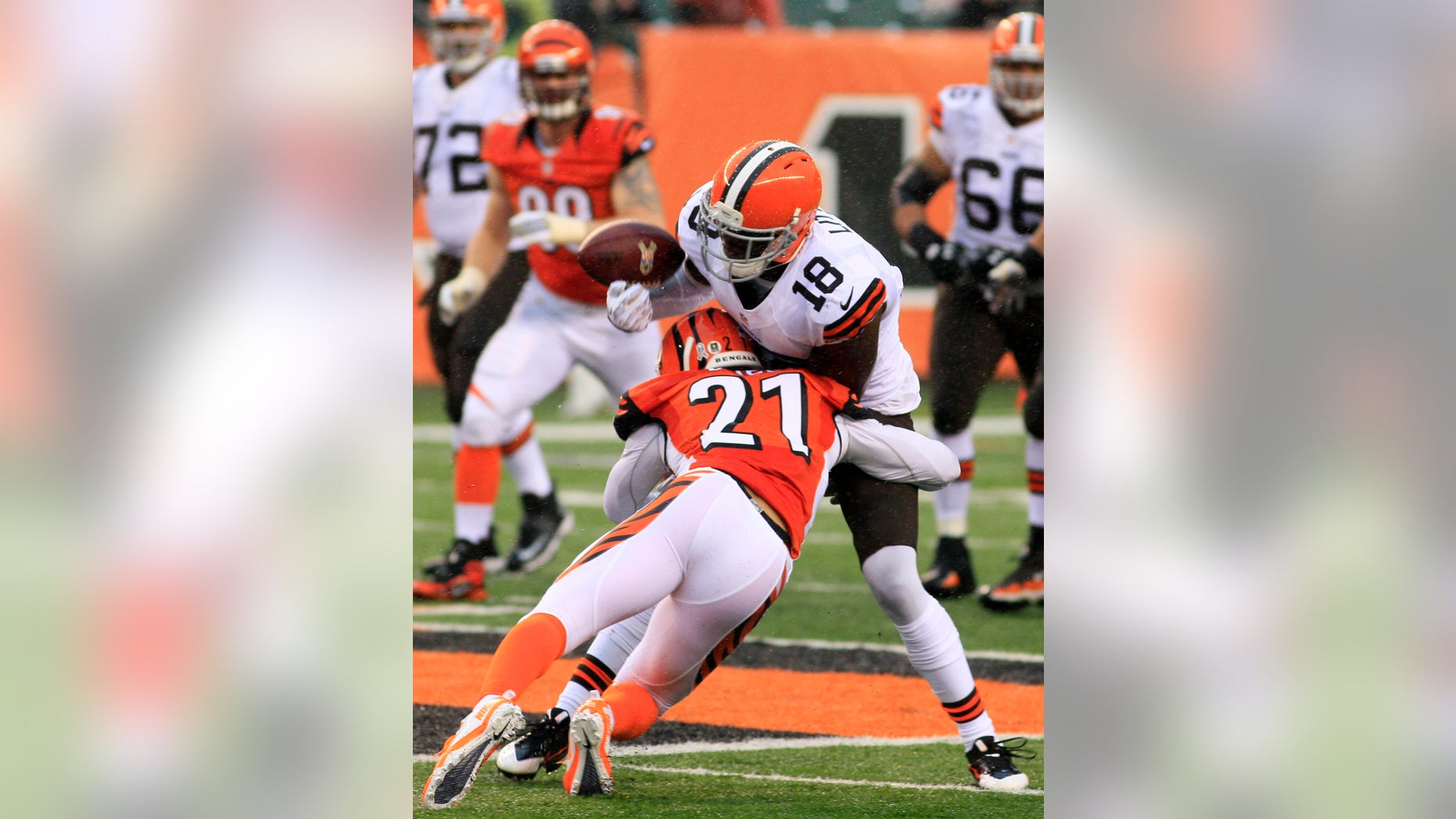 Cleveland Browns wide receiver Greg Little (18) fumbles the ball as he is hit by Cincinnati Bengals defensive back Brandon Ghee (21) in the second half of an NFL football game, Sunday, Nov. 17, 2013, in Cincinnati. (AP Photo/Tom Uhlman)