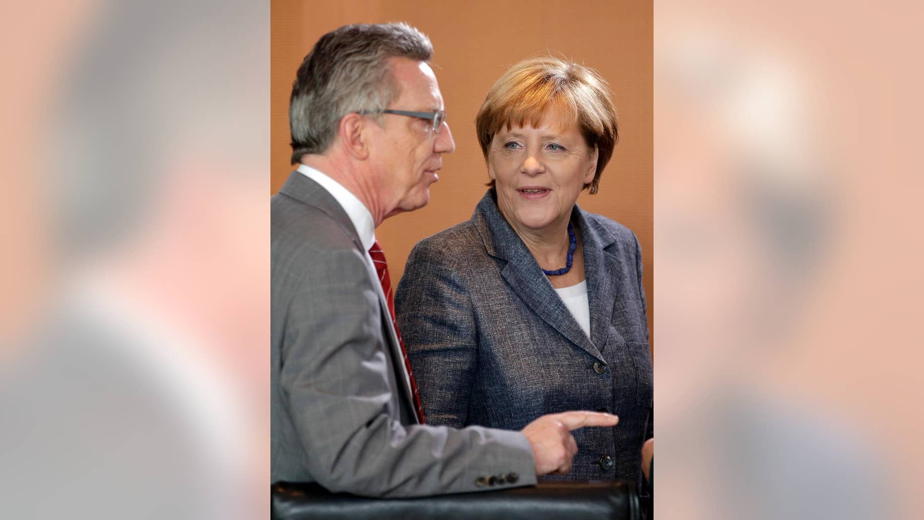 German Chancellor Angela Merkel, right, talks to German Interior Minister Thomas de Maiziere, left, at the beginning of a special meeting of the cabinet on migrants at the chancellery in Berlin, Germany, Tuesday, Sept. 15, 2015. (AP Photo/Michael Sohn)