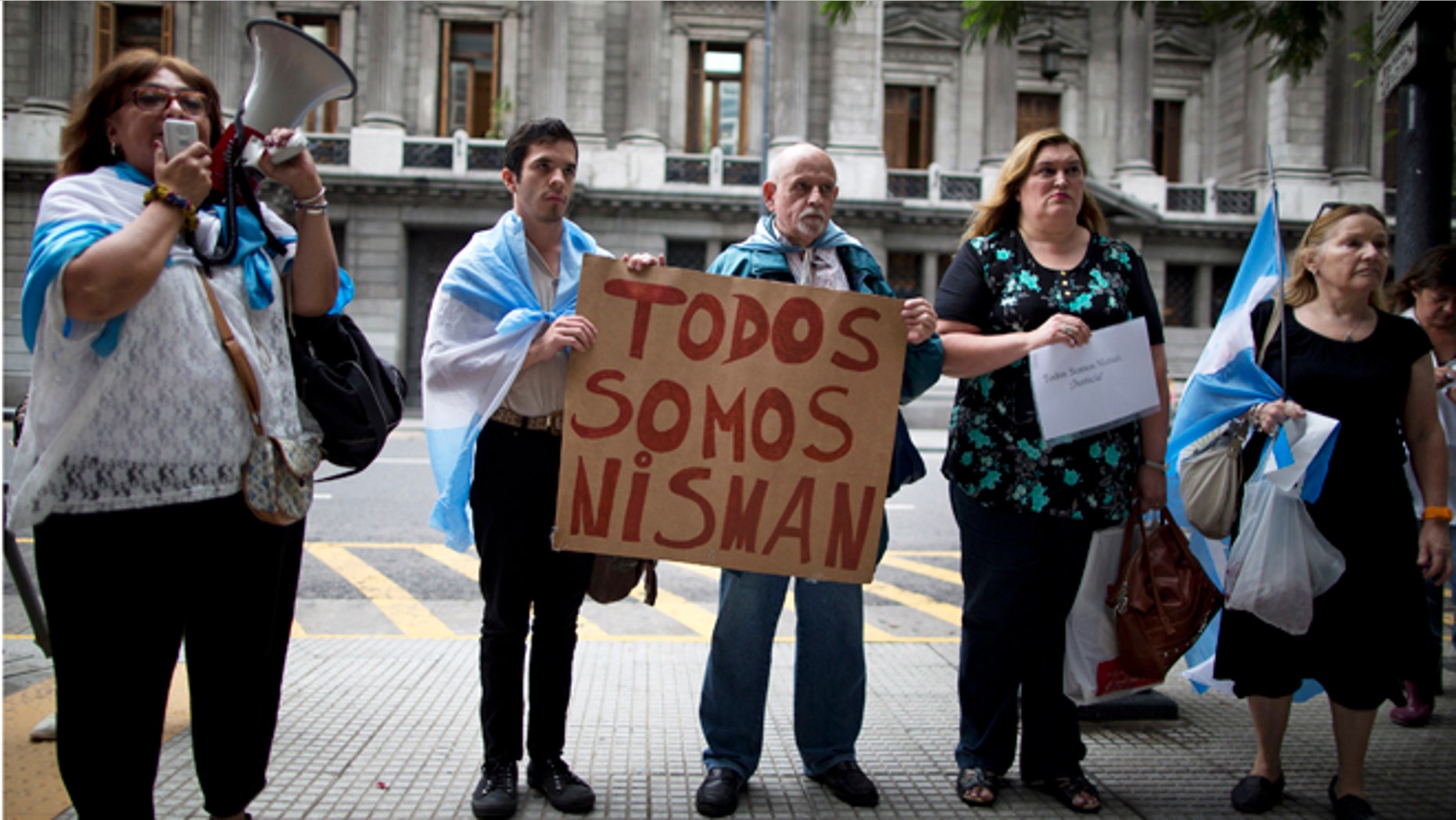 People holding a sign that reads in Spanish "We are all Nisman," protest the death of special prosecutor Alberto Nisman, outside Congress in Buenos Aires, Argentina, Monday, Jan. 19, 2015. Nisman who accused the government of secret deals with Iran over an investigation into a 1994 Argentine-Israeli Mutual Association community center terrorist attack, was found dead with a gunshot wound, at his apartment early Monday. Nisman was due to participate in a closed-door session with Congress Monday over his claim last week that Argentine President Cristina Fernandez and Foreign Minister Hector Timerman covered up a deal with Iran. (AP Photo/Rodrigo Abd)