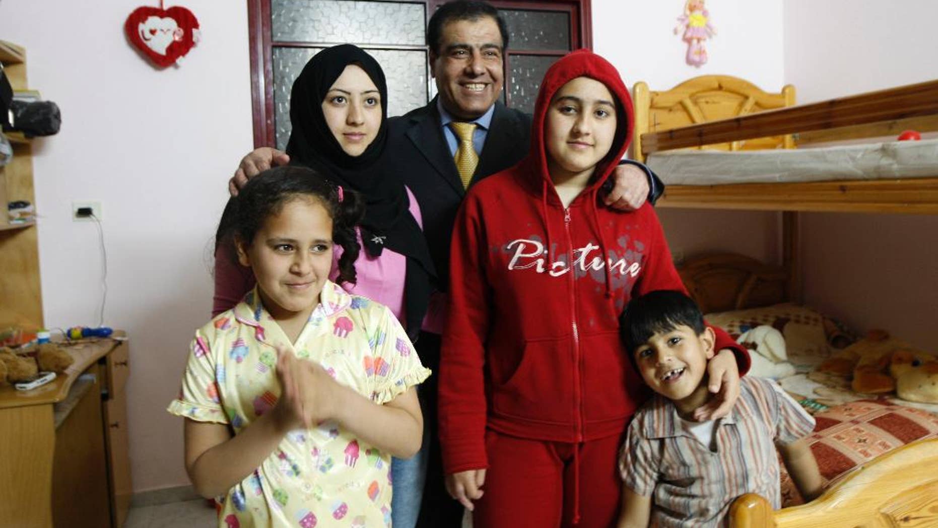 FILE - In this May 7, 2009 file photo, Palestinian Dr. Izzeldin Abuelaish poses for a picture with his children in his house in Jebaliya, northern Gaza Strip. Dr. Abuelaish has made an emotional appeal to Israel to apologize for killing three of his daughters and a niece in a 2009 shelling attack on his Gaza home, speaking on the eve of a hearing in his civil suit, urged the state Tuesday to "take responsibility." (AP Photo/Khalil Hamra, File)