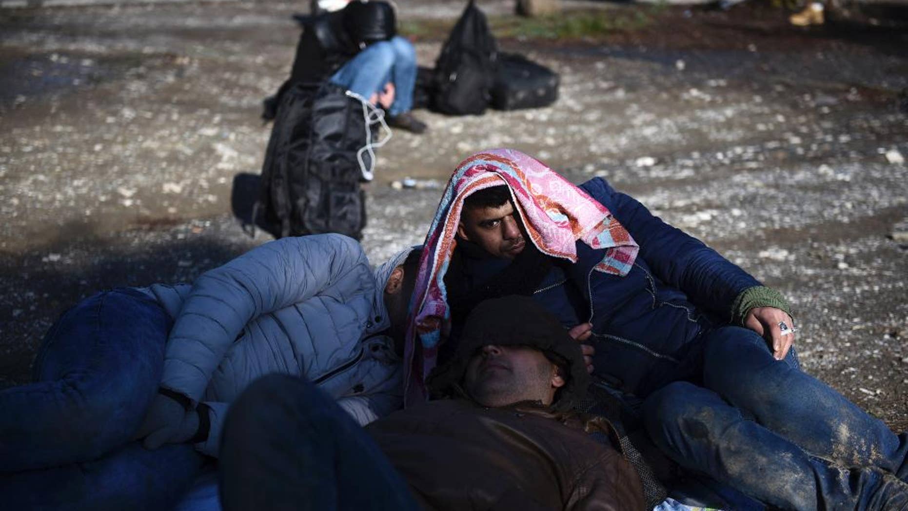 Syrian refugees wait to be picked up by the police on the outskirts of the northern Greek city of Thessaloniki, on Wednesday, Nov. 30, 2016. Authorities in Greece say they have picked up about 70 migrants, including children, found in the forested area after a truck driver left them and they spent the night there in the snow. (AP Photo/Giannis Papanikos)