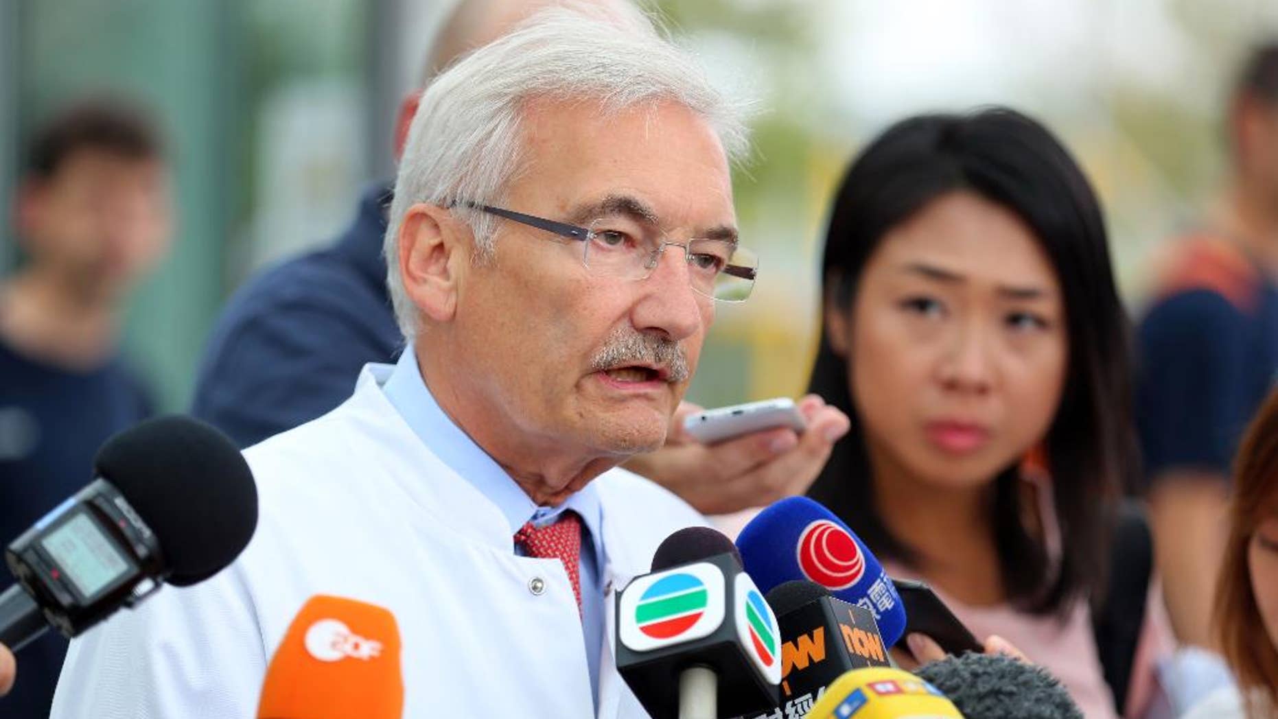 Medical director of the University Hospital in Wuerzburg, Georg Ertl, speaks to the media about the health condition of victims of an ax and knife attack by a refugee in Wuerzburg, Germany, Thursday July 21, 2016. Two Hong Kong tourists remained in a critical condition, the hospital treating them said Thursday, three days after they were attacked by an Afghan refugee wielding an ax and a knife on a German commuter train. The Islamic State group claimed responsibility for the attack. ( Karl-Josef Hildenbrand/dpa via AP)