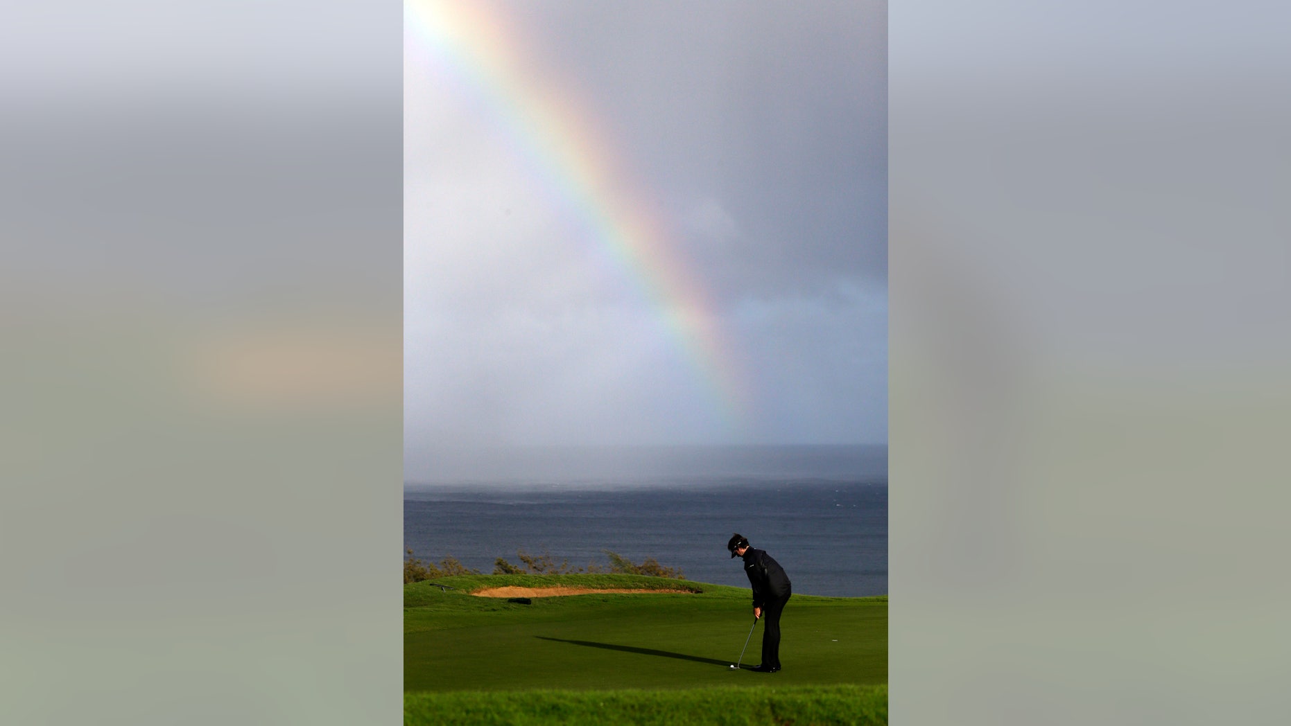 Bubba Watson putts in view of a rainbow behind on the 13th hole during the first round at the Tournament of Champions PGA golf tournament, Monday, Jan. 7, 2013, in Kapalua, Hawaii. Play was to have started three days earlier, but was delayed because of rain and high winds. (AP Photo/Elaine Thompson)