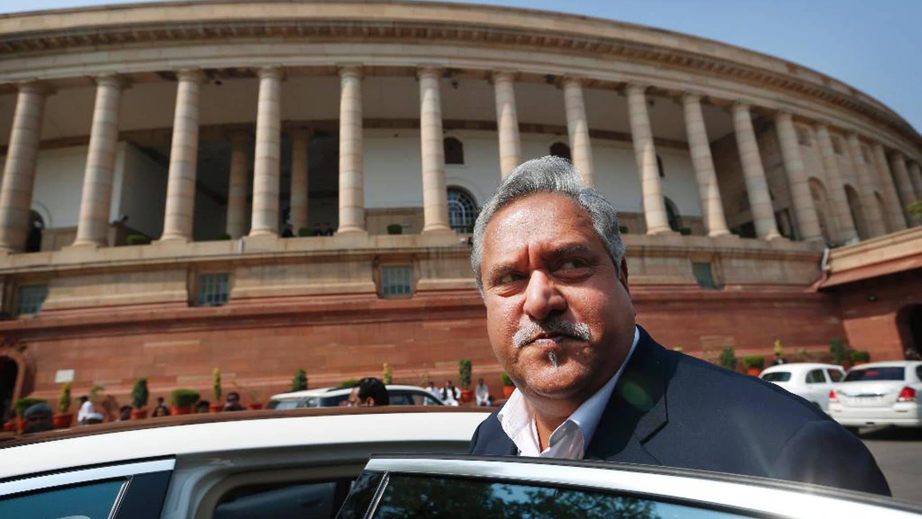 FILE- In this Feb. 27, 2013 file photo, Indian business tycoon and owner of Kingfisher Airlines Vijay Mallya gets into his car outside the Parliament in New Delhi, India. India has revoked the passport of the flamboyant Indian businessman Mallya accused of fleeing to London in March while owing more than a billion dollars to Indian banks. External Affairs Ministry spokesman Vikas Swarup said Sunday, April 24, 2016 that the decision to revoke Mallya's passport was taken considering the evidence gathered by India's Enforcement Directorate, which has been investigating the tycoon's massive debts. (AP Photo/Saurabh Das, file)