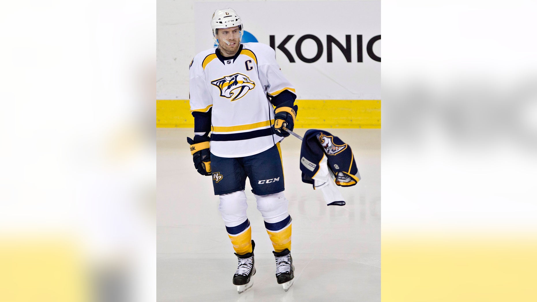 Nashville Predators Shea Weber (6) picks up a Predators jersey thrown on the ice by a fan during third period of an NHL hockey game in Edmonton, Alberta, Sunday, Jan. 26, 2014. (AP Photo/The Canadian Press, Jason Franson)