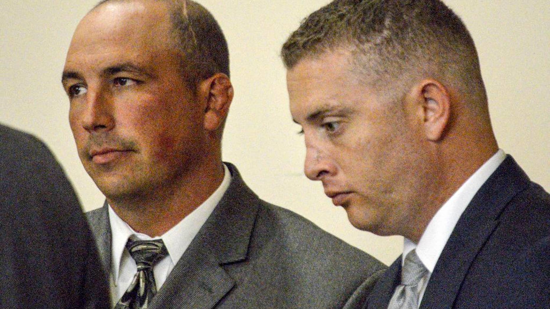 FILE - In this Aug. 18, 2015 file photo, former Albuquerque Police detective Keith Sandy, left, and Officer Dominique Perez speak with attorneys during a preliminary hearing in Albuquerque, N.M., on Tuesday, Aug. 18, 2015. They are expected to be arraigned Friday, Sept. 11, 2015 on second-degree murder charges in the on-duty shooting death of a homeless man who authorities say suffered from mental illness.(AP Photo/Russell Contreras, File)