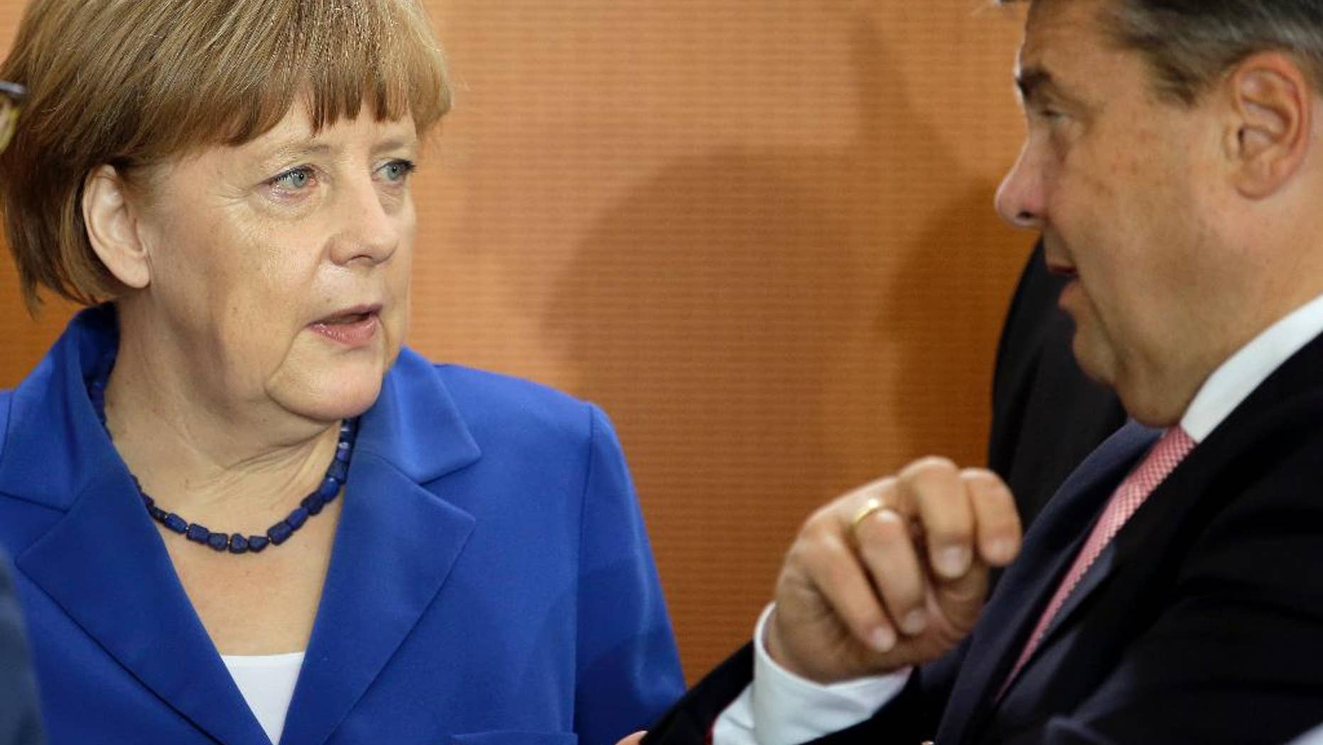 German Chancellor Angela Merkel, left, and Vice Chancellor and Economy Minister Sigmar Gabriel, right, talk as they arrive for the weekly cabinet meeting at the chancellery in Berlin, Germany, Wednesday, May 6, 2015. (AP Photo/Michael Sohn)