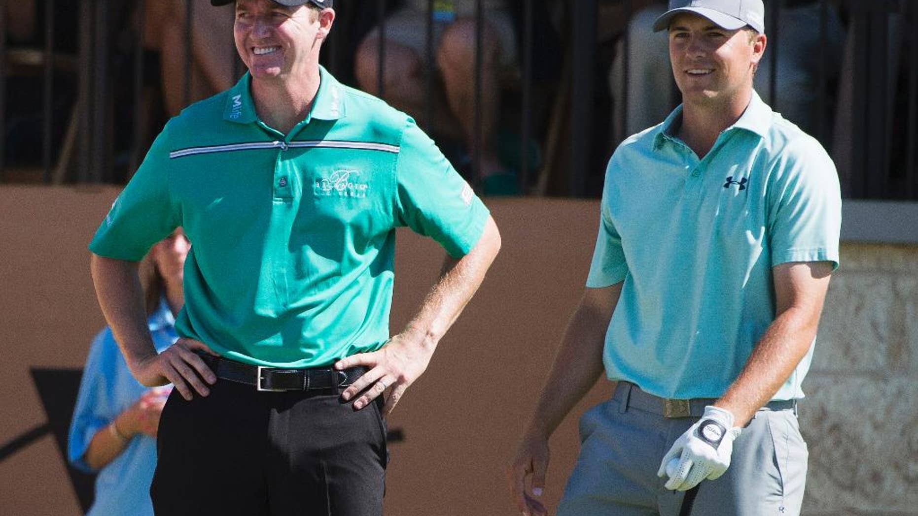 Jimmy Walker, left, and Jordan Spieth talk on the 16th tee during the final round of the Valero Texas Open golf tournament, Sunday, March 29, 2015, in San Antonio. Walker won the tournament. (AP Photo/Darren Abate)