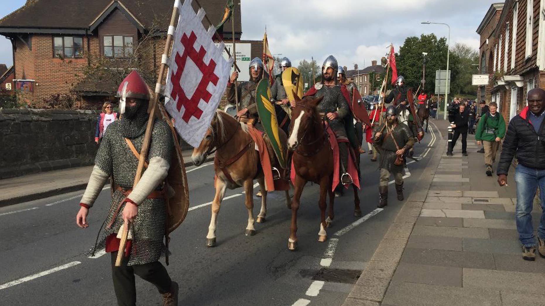 A group of historical re-enactors arrive in Battle, near Hastings, England, Friday Oct. 14, 2016, ending their 300-mile cross-country journey ready to mark the Battle of Hastings which was originaly fought 950-years ago. The band of re-enactor enthusiasts set out from York, central England, on foot and horseback to simulate the journey by King Harold before the battle in 1066, when Normans under William the Conqueror defeated the English at the Battle of Hastings. (Tom Pugh / PA via AP)