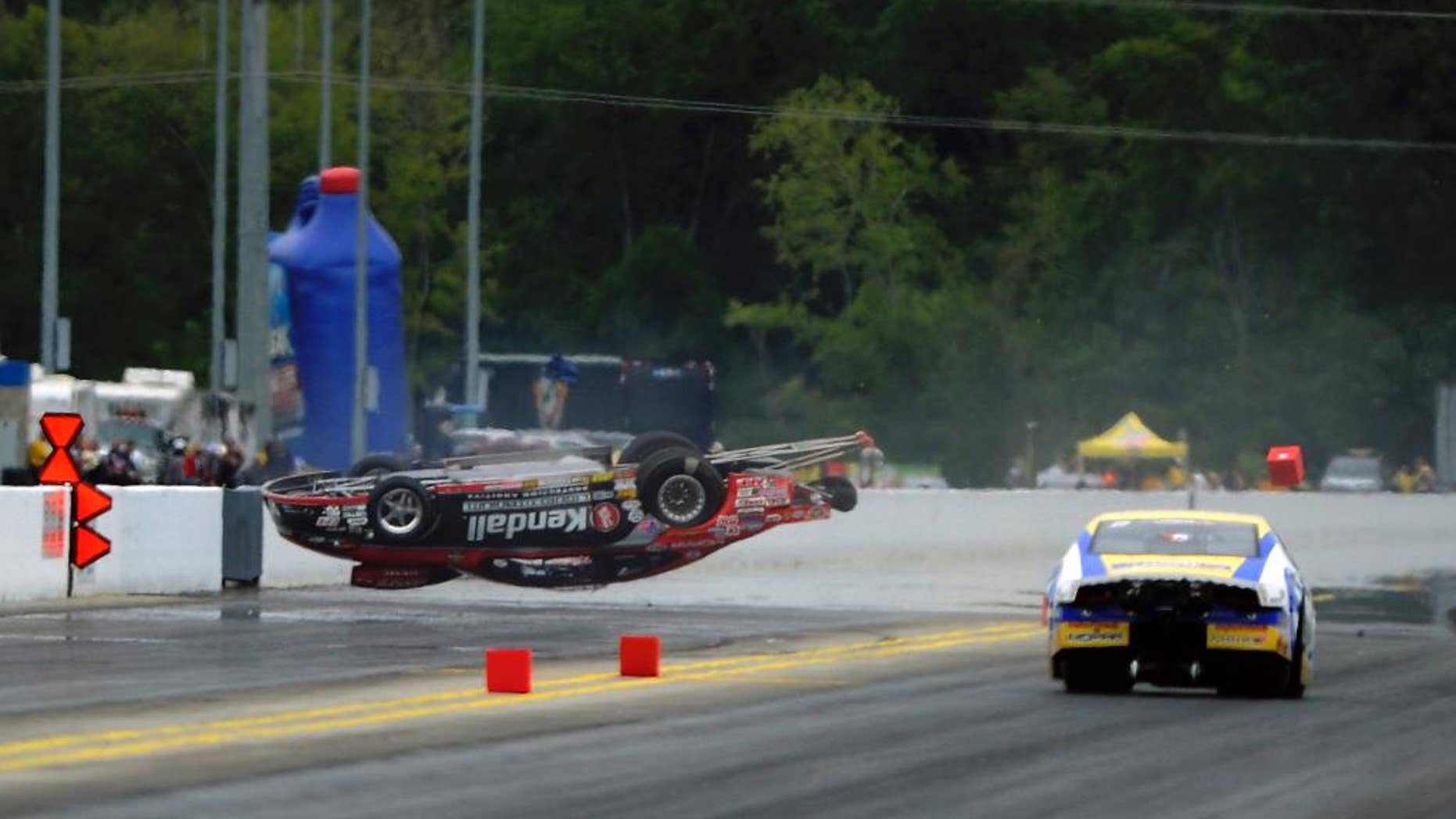 In this photo provided by the NHRA, Vieri Gaines goes airborne during a first-round victory over Allen Johnson in Pro Stock at the Pep Boys NHRA drag races Sunday, Sept. 14, 2014, at zMAX Dragway in Concord, N.C. Gaines was not injured in the incident. (AP Photo/NHRA, Marc Gewertz)