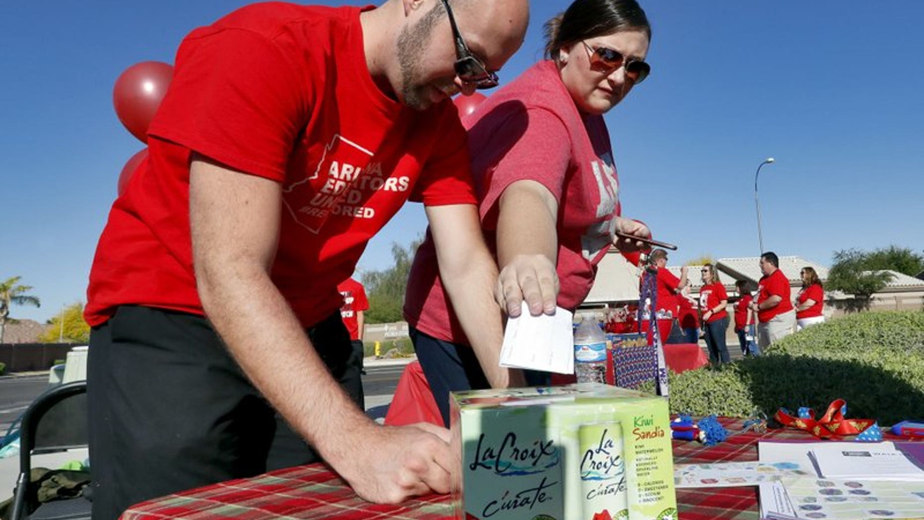 In this April 18, 2018 photo, two Arizona teachers cast their ballots outside Paseo Verde Elementary. Arizona teachers Thursday to walk out of their classrooms to demand more school funding after weeks of growing protests.