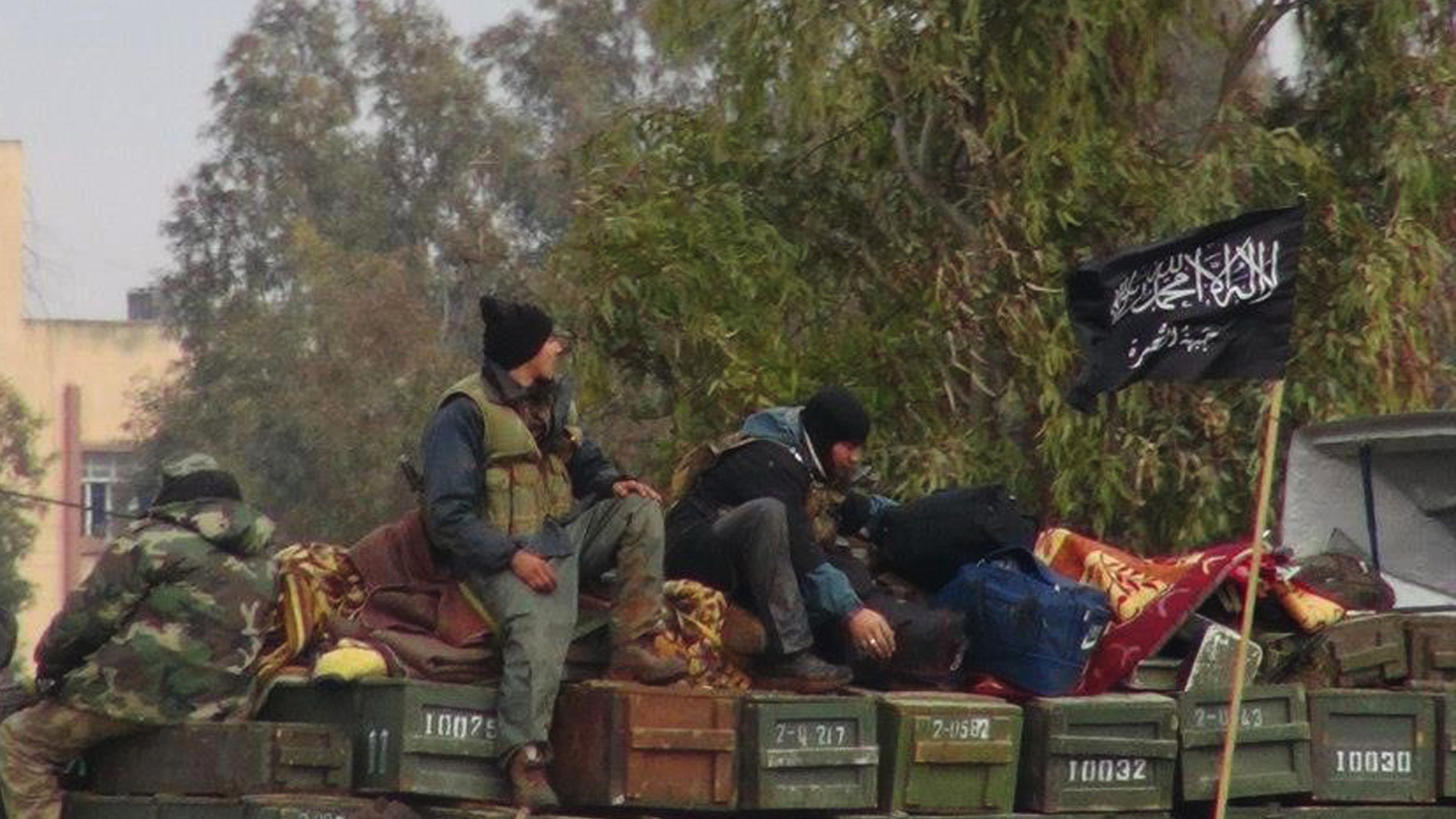 FILE - In this Friday, Jan. 11, 2013 file citizen journalism image provided by Edlib News Network, ENN, which has been authenticated based on its contents and other AP reporting, shows rebels from al-Qaida affiliated Jabhat al-Nusra, as they sit on a truck full of ammunition, at Taftanaz air base, that was captured by the rebels, in Idlib province, northern Syria. An Islamist extremist group affiliated with al-Qaida, Jabhat al-Nusra has emerged as one of the most powerful rebel factions on the battlefield.(AP Photo/Edlib News Network, ENN, File)