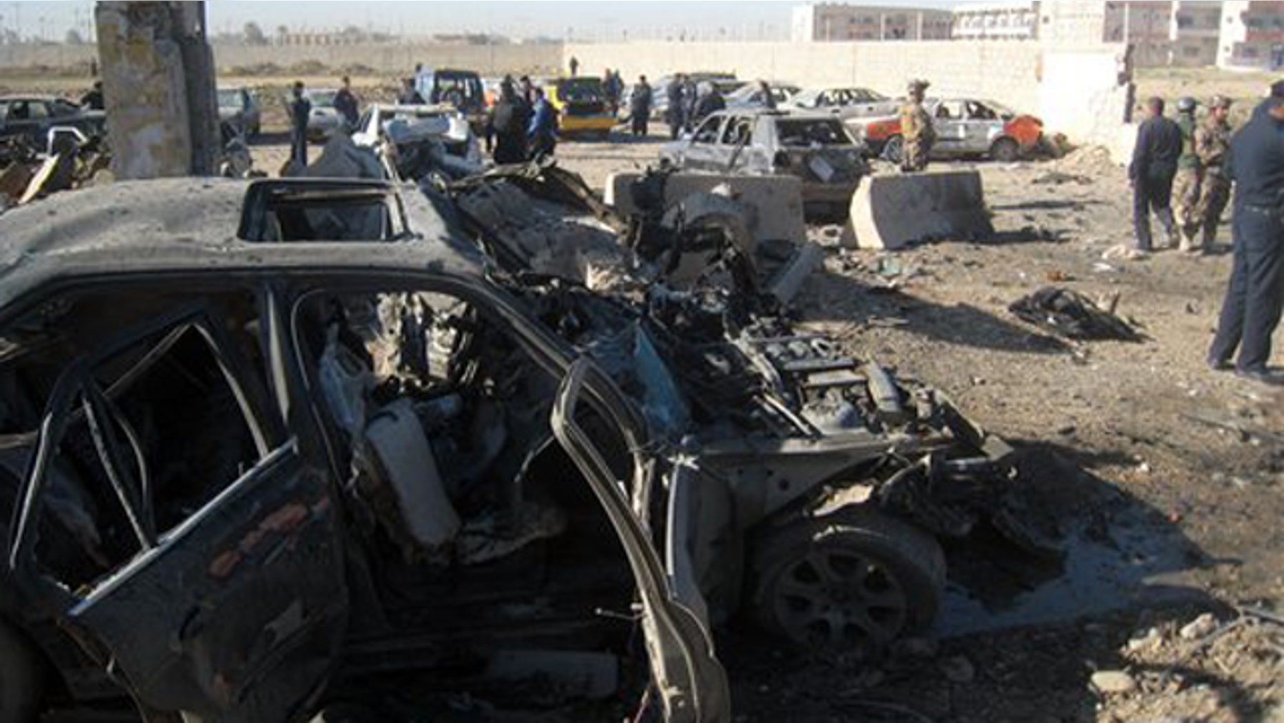 Mar. 20, 2012: People and security forces inspect the scene of a car bomb attack in Kirkuk.