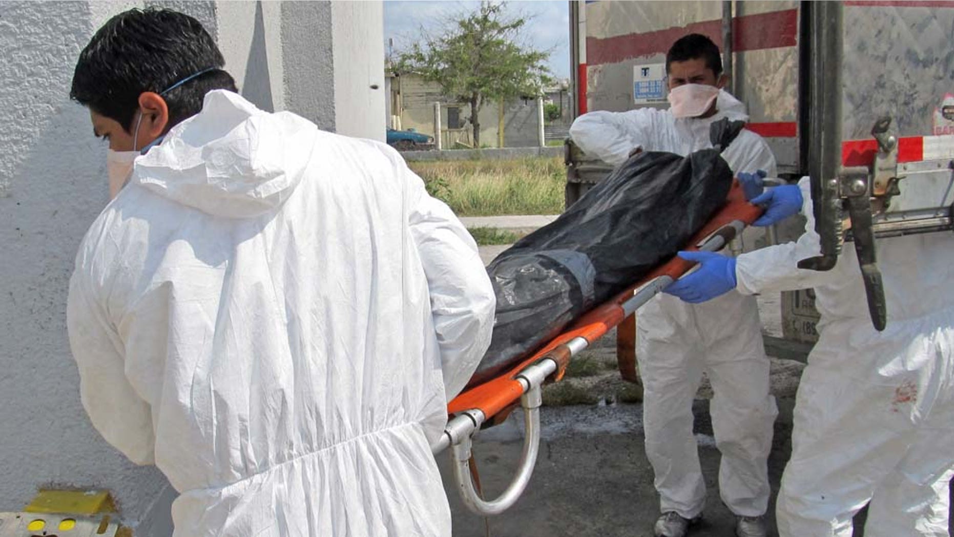 Morgue employees unload a body from a refrigerated truck into the local morgue in Matamoros, northern Mexico, Wednesday April 13, 2011. Mexican investigators have found a total of 116 bodies in Tamaulipas state in pits near the U.S. border, 28 more than previously reported, Attorney General Marisela Morales said Tuesday. Morales said a total of 17 suspects have been detained in relation to the killings in the northern state of Tamaulipas, some of whom have purportedly confessed to abducting passengers from buses and killing them. (AP Photo/Rubios News)