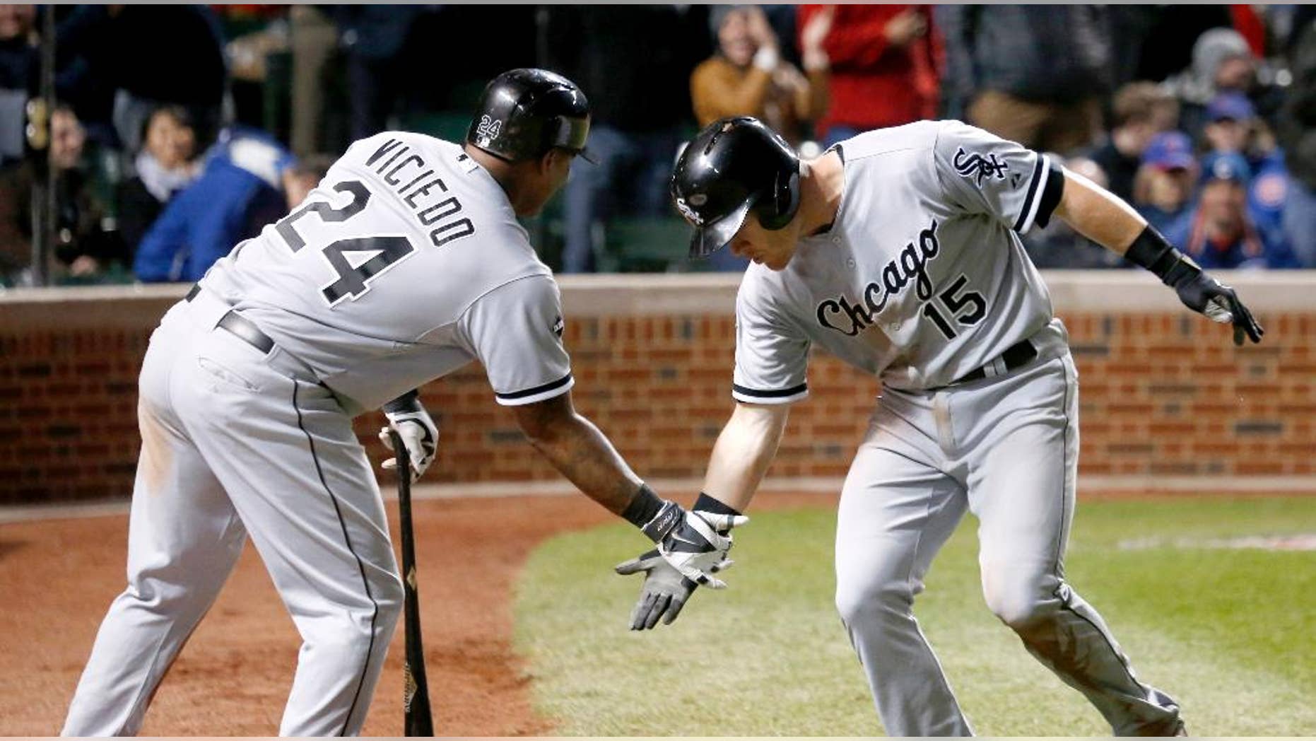 Chicago White Sox's Gordon Beckham, right, celebrates his home run off Chicago Cubs relief pitcher Neil Ramirez with Dayan Viciedo during the eighth inning of an interleague baseball game Tuesday, May 6, 2014, in Chicago. (AP Photo/Charles Rex Arbogast)