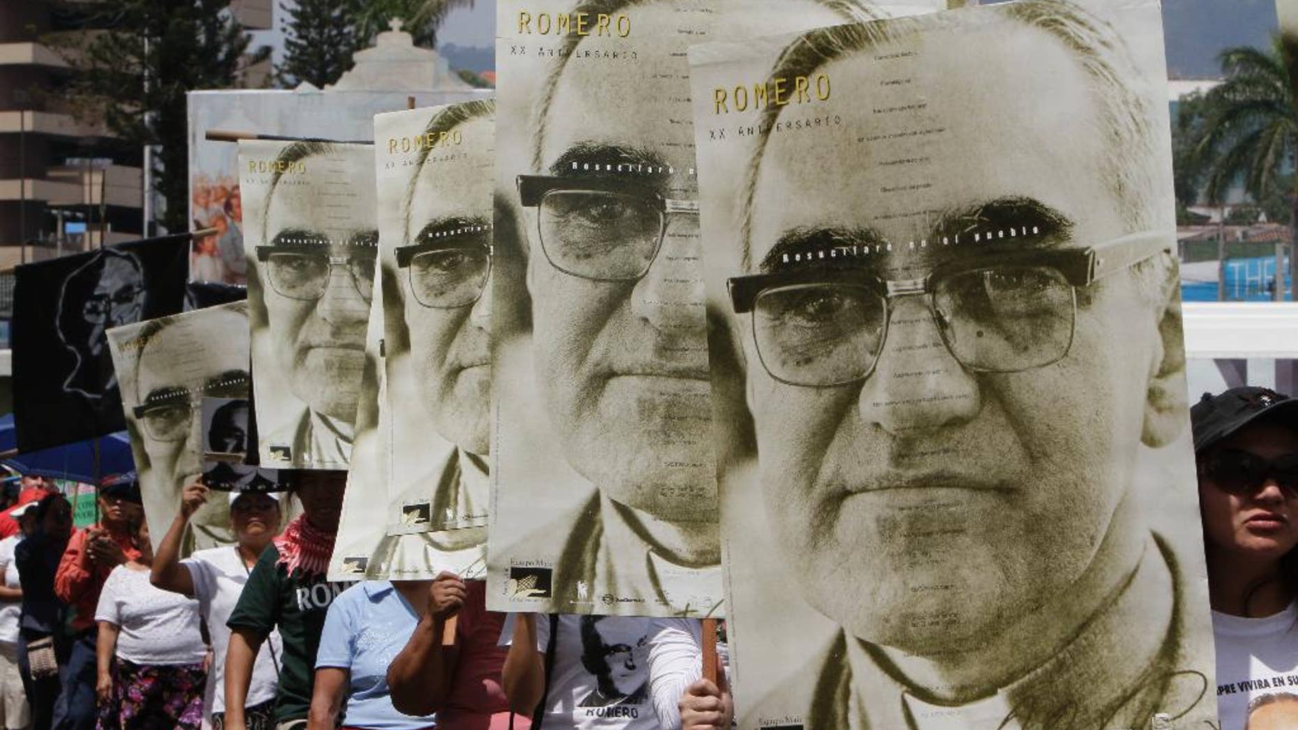 FILE - In this March 24, 2011 file photo, protesters carry portraits of slain Archbishop Oscar Arnulfo Romero on the 31st anniversary of his death in San Salvador, El Salvador. Perpetrators of human rights violations during El Salvador’s civil war such as Romero’s 1980 assassination could be prosecuted now that the country’s Supreme Court struck down an amnesty law protecting them, in a July 13, 2016 decision. Romero was fatally shot on orders by an official in El Salvador's U.S.-backed army as he celebrated Mass. (AP Photo/Luis Romero, File)