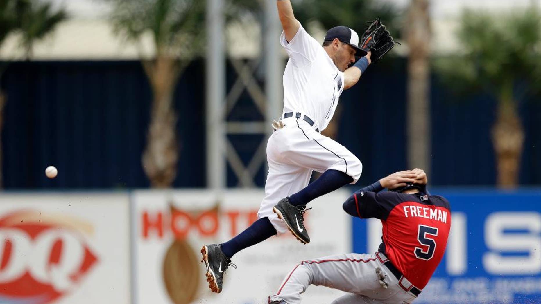 Detroit Tigers second baseman Ian Kinsler loses control of the ball as Atlanta Braves first baseman Freddie Freeman, right, slides under for a steal during the third inning of a spring exhibition baseball game in Lakeland, Fla., Tuesday, March 25, 2014. (AP Photo/Carlos Osorio)
