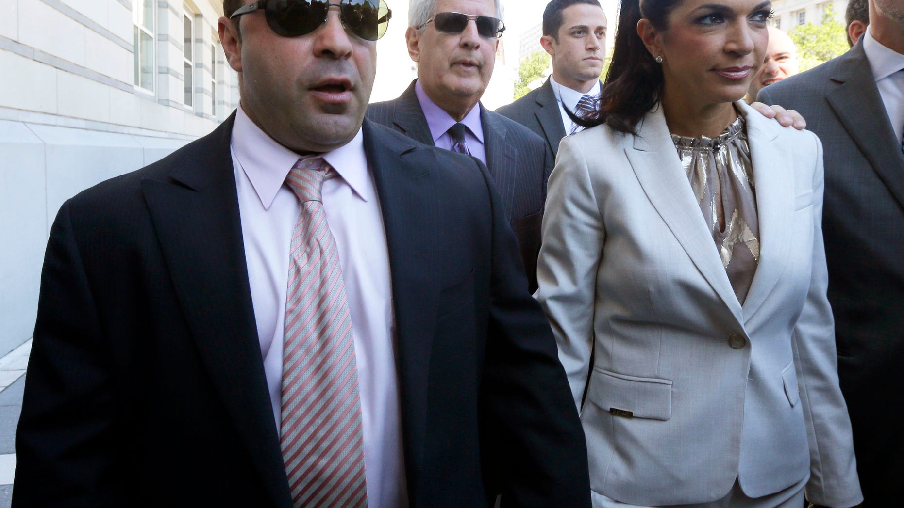 FILE - In this July 30, 2013 file photo, “The Real Housewives of New Jersey” stars Giuseppe "Joe" Giudice, left, and his wife, Teresa Giudice, of Montville Township, N.J., walk out of Martin Luther King Jr. Courthouse after an appearance in Newark, N.J. The Giudices are facing additional fraud charges as they were each indicted Monday, Nov. 18, 2013, on one count of bank fraud and one count of loan application fraud. Monday's charges are in addition to a 39-count indictment handed down in July, charging the couple with conspiracy to commit mail and wire fraud, bank fraud, making false statements on loan applications and bankruptcy fraud. (AP Photo/Julio Cortez, File)