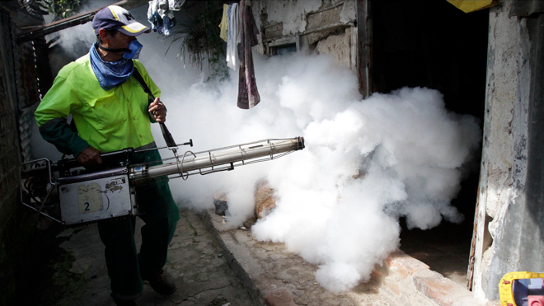 Employees of the Municipality of San Salvador, fumigate houses in the northern area of the capital city, to eliiminate the Aedes Egypt mosquito, transmitters of the dengue disease in San Salvador , El Salvador , Friday ,Aug. 17,2012. According to health minister Maria Isabel Rodriguez the ministry is considering to declare national emergency due to the increase of Dengue cases with 2.301 people currently hospitalized.(AP Photo/Luis Romero)