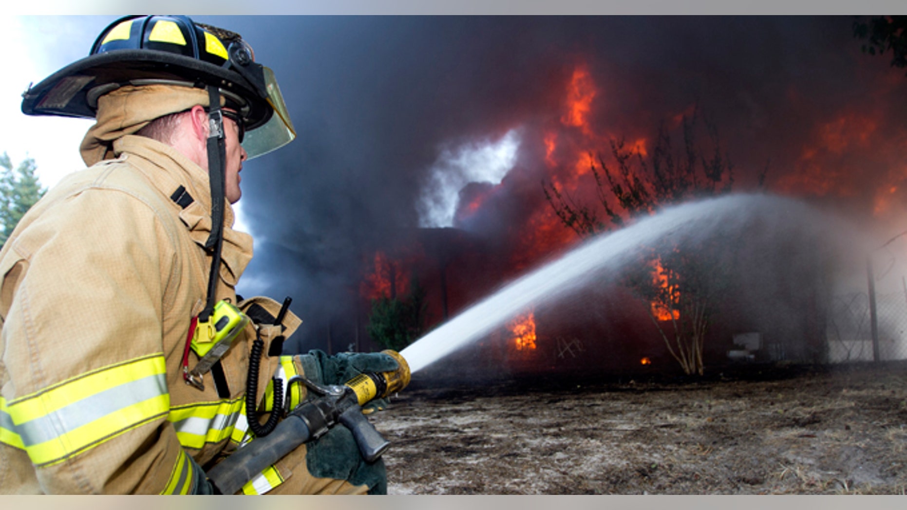 Eric Thomas, a Red Oak firefighter, hoses down the home of Richard Nixon of rural Jefferson, Texas as it becomes fully engulfed in flames Thursday, Sept. 8, 2011. Nearly 1,400 homes have been destroyed about 25 miles east of Austin and about 5,000 residents have been forced to leave their homes. (AP Photo/ The Texarkana Gazette,Adam Sacasa)