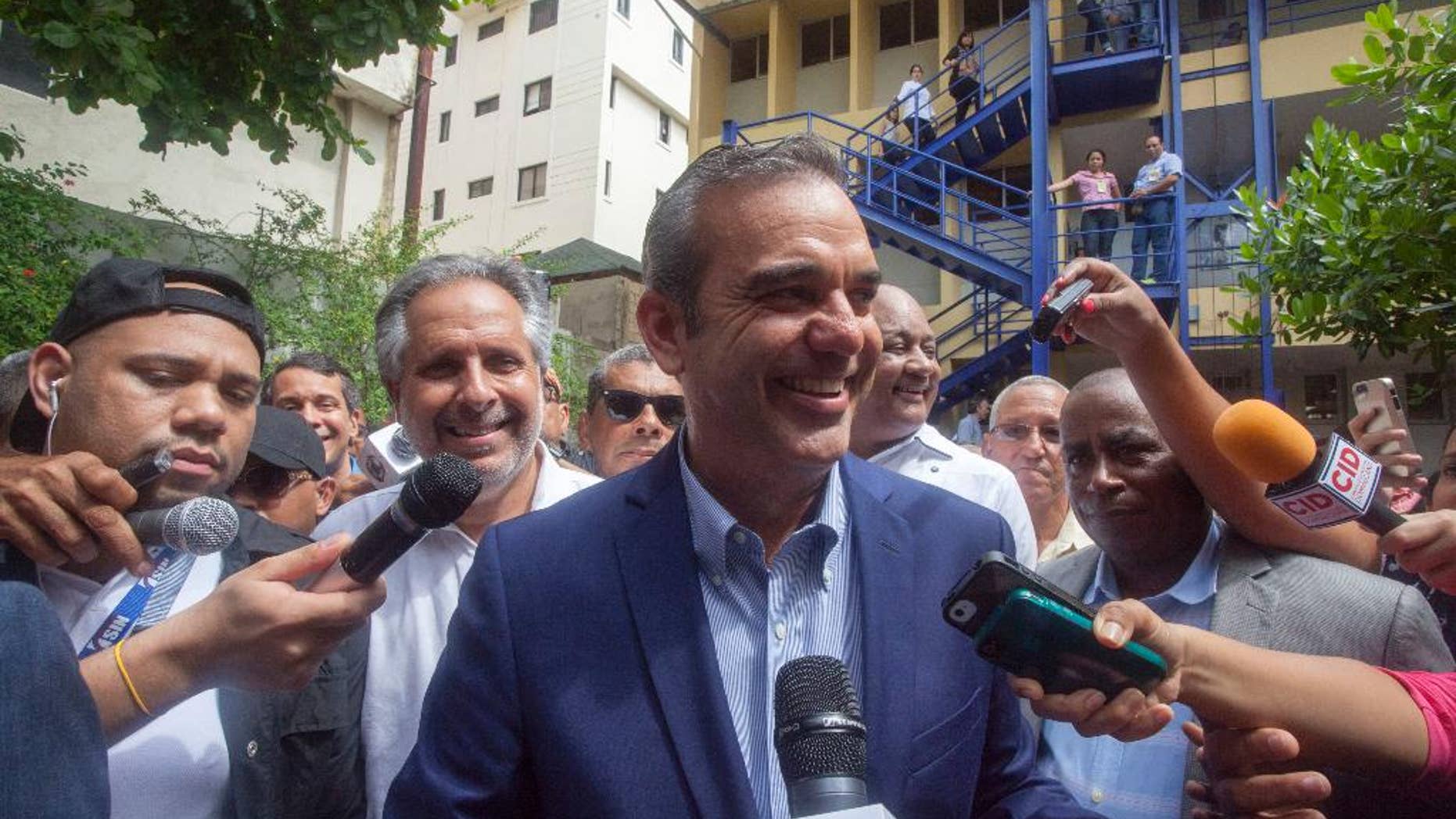 Luis Abinader, center, presidential candidate of the opposition Modern Revolutionary Party, speaks to the press after voting at the presidential, congressional and municipal elections in Santo Domingo, Dominican Republic, Sunday, May 15, 2016. Dominicans faced a dizzying array of choices Sunday in one of the most complex ballots in recent history, with eight candidates for president, all 222 members of Congress up for re-election and thousands of people vying for local offices around the country. Second from left behind Abinader is candidate for Mayor Alberto Atallah.(AP Photo/Tatiana Fernandez)