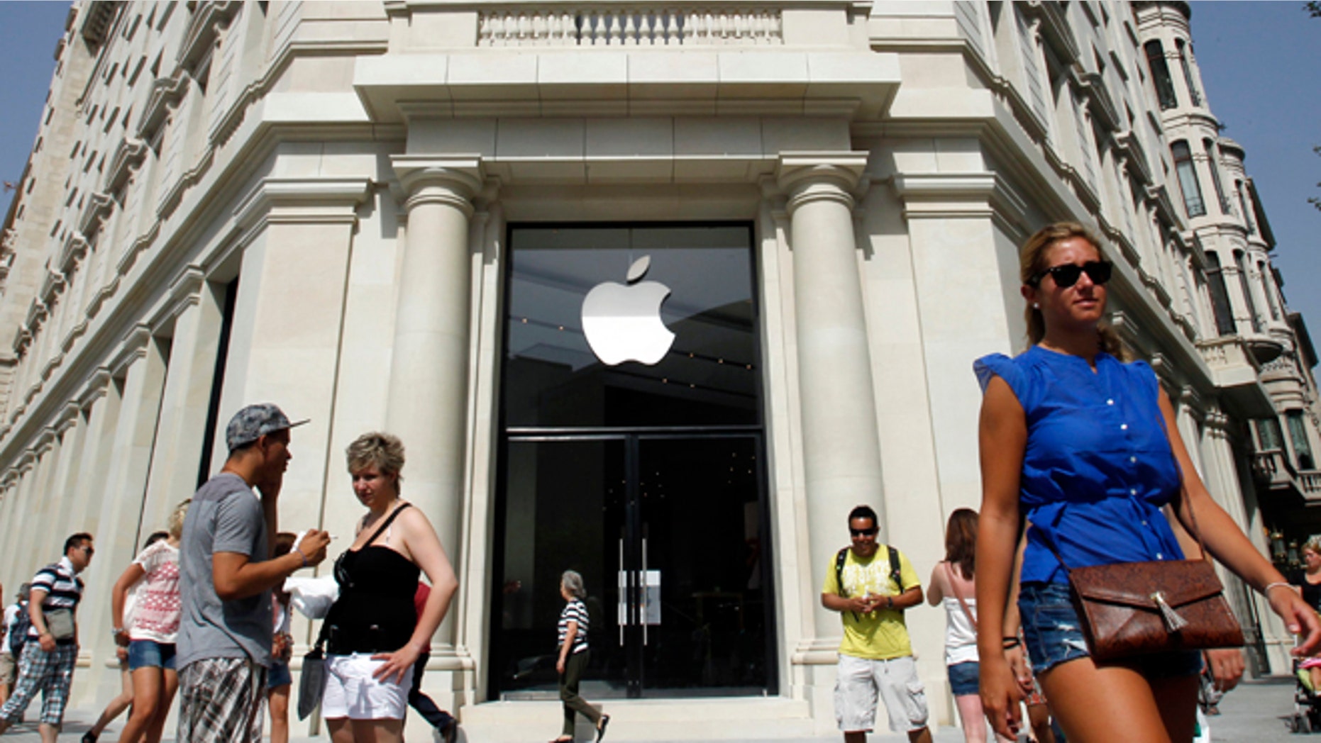 July 26: People walk past a closed shop, which will be opened and inaugurated as the largest Apple store in southern Europe at Passeig de Gracia, in Barcelona.