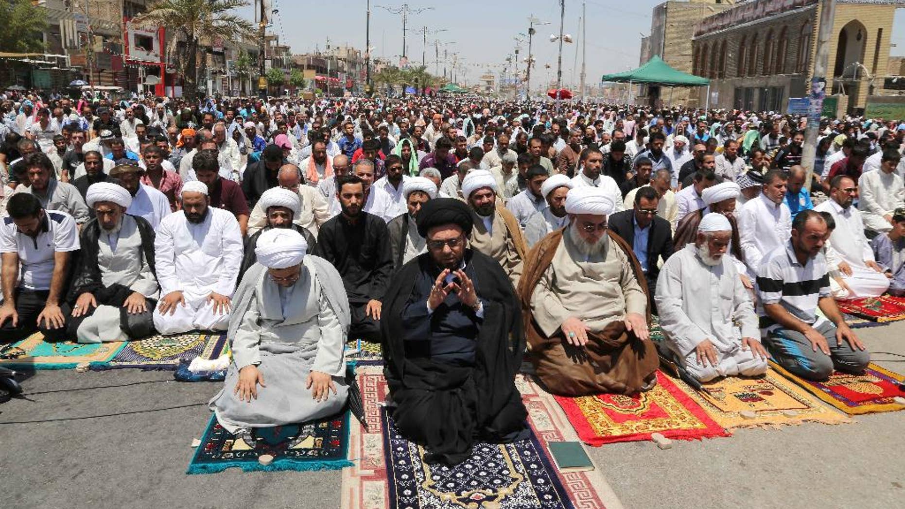 Followers of Shiite cleric Muqtada al-Sadr attend open-air Friday prayers in the Shiite stronghold of Sadr City, Baghdad, Iraq, Friday, July 11, 2014. The lightning sweep by the militants over much of northern and western Iraq the past month has dramatically hiked tensions between the country's Shiite majority and Sunni minority. At the same time, splits have grown between the Shiite-led government in Baghdad and the Kurdish autonomous region in the north. (AP Photo/Karim Kadim)