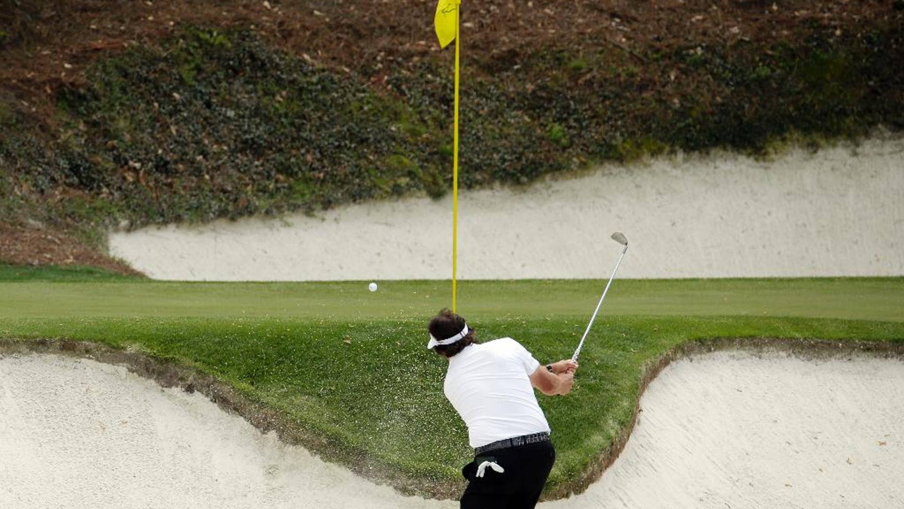 Phil Mickelson hits out of a bunker on the 12th hole during the second round of the Masters golf tournament Friday, April 11, 2014, in Augusta, Ga. (AP Photo/Charlie Riedel)