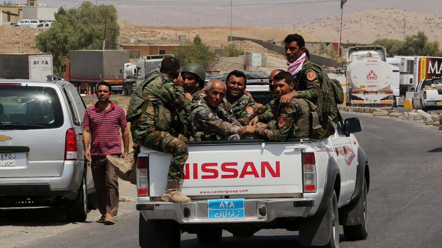 Kurdish forces, known as the Peshmerga, make their way to the front line to fight militants from the extremist Islamic State group at Mosul Dam, outside Mosul, Iraq, Monday, Aug 18, 2014. Boosted by two days of U.S. airstrikes, Iraqi and Kurdish forces on Monday wrested back control of the country's largest dam from Islamic militants, a military spokesman in Baghdad said, as fighting was reported to be underway for the rest of the strategic facility. (AP Photo/Khalid Mohammed)
