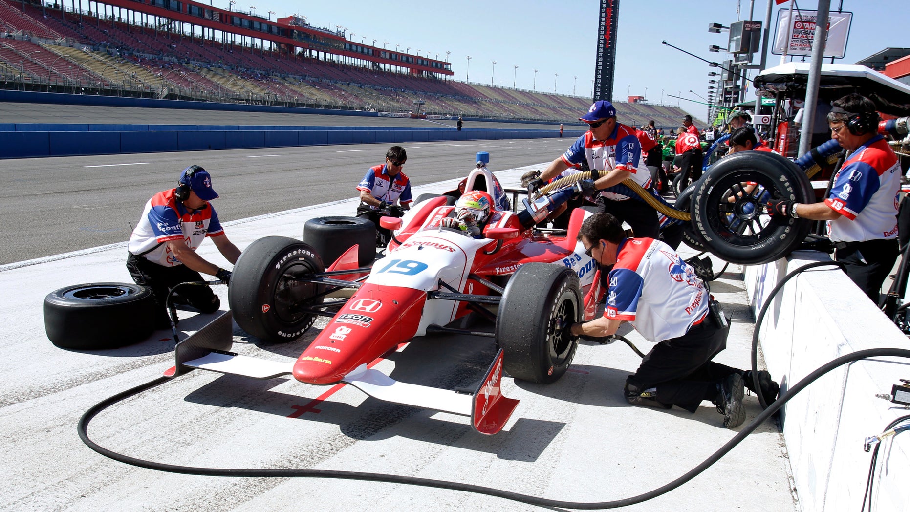 CORRECTS DAY OF RACE TO SATURDAY, INSTEAD OF SUNDAY - Justin Wilson, of England, gets new tires during a practice session for Saturday's IndyCar auto race at Auto Club Speedway, Friday, Oct. 18, 2013, in Fontana, Calif. (AP Photo/Alex Gallardo)