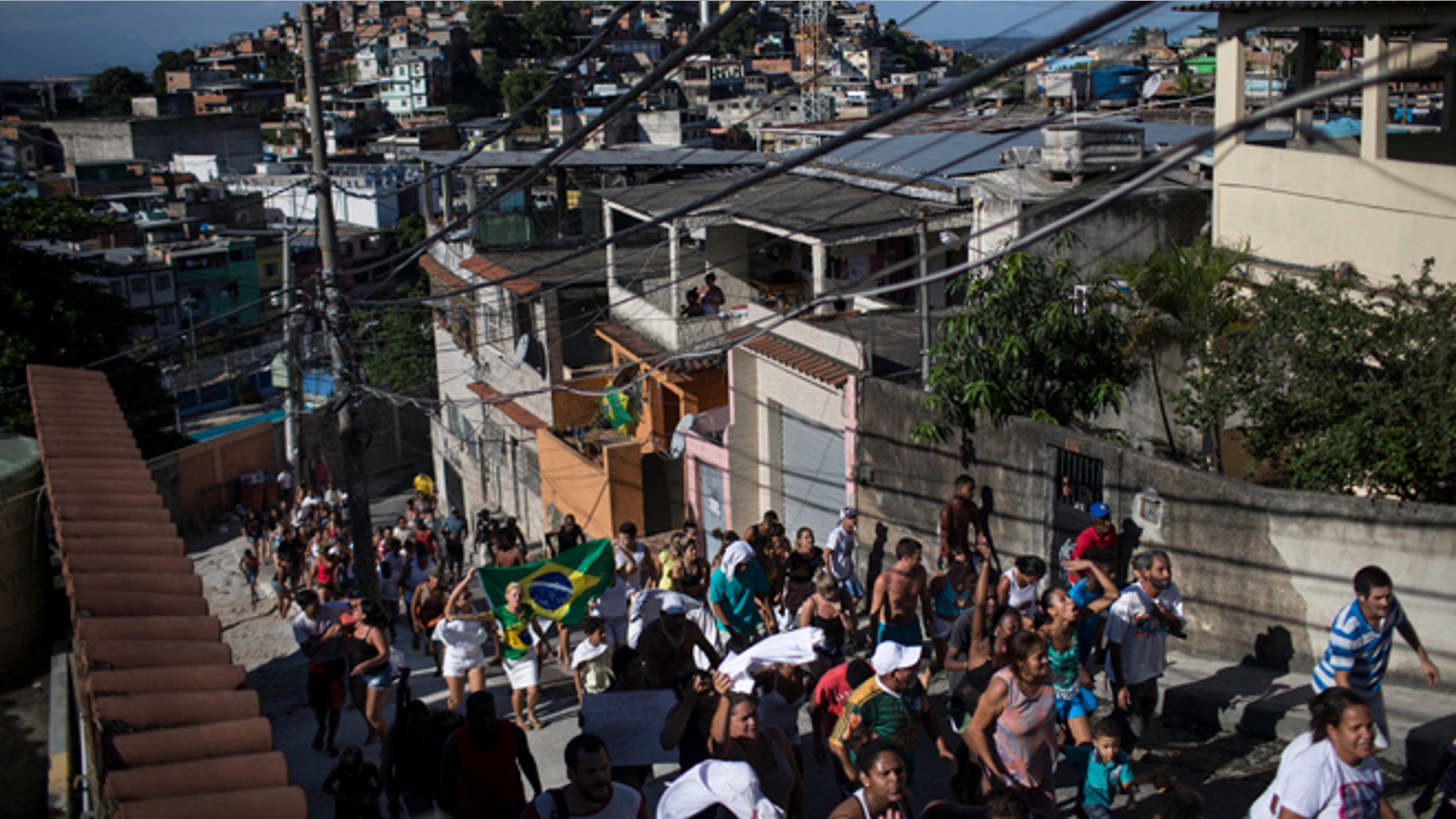 Residents take part in a protest march calling attention to the violence that erupts during police operations against suspected drug traffickers, in the Alemao slum complex in Rio de Janeiro, Brazil, Friday, April 3, 2015. Residents are protesting the shooting deaths of a young boy and a 41-year-old housewife, who were killed by stray bullets in the past few days. (AP Photo/Felipe Dana)