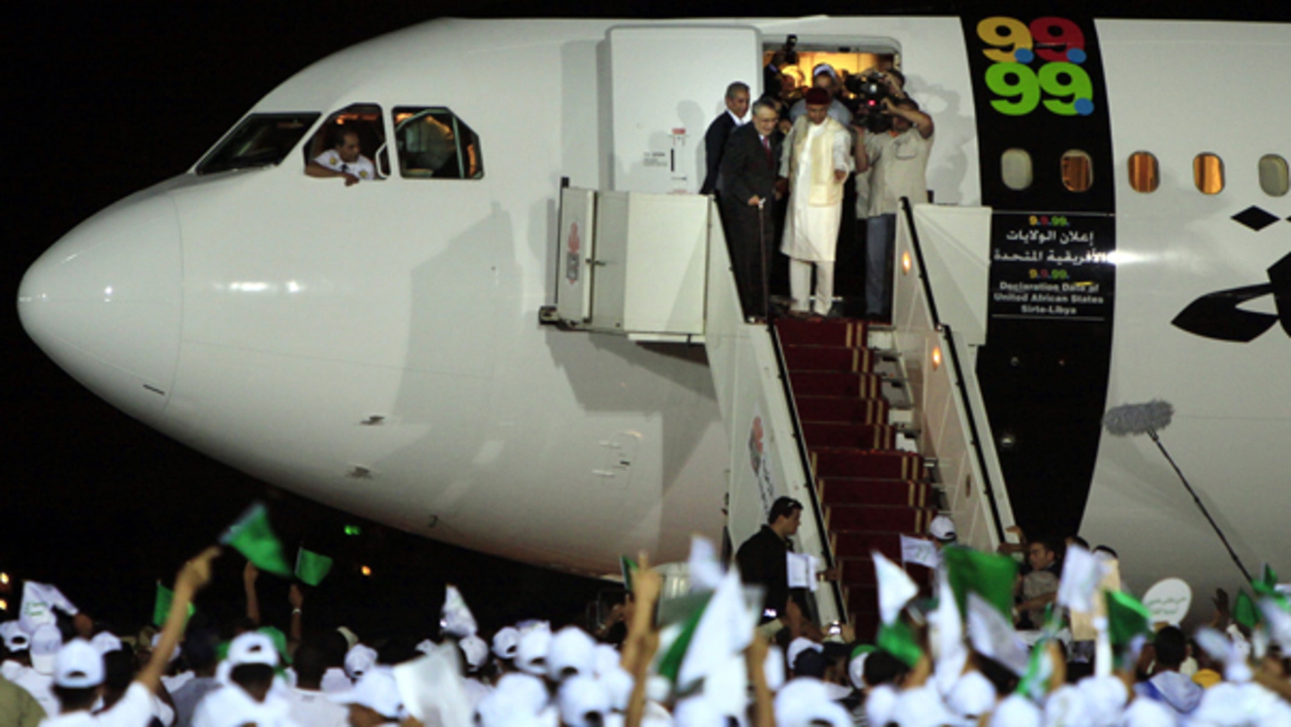In this Aug. 20, 2009 file photo, hundreds of Libyans an airport in Tripoli welcome Abdel Baset al-Megrahi, who was found guilty of the 1988 Lockerbie bombing, top left.