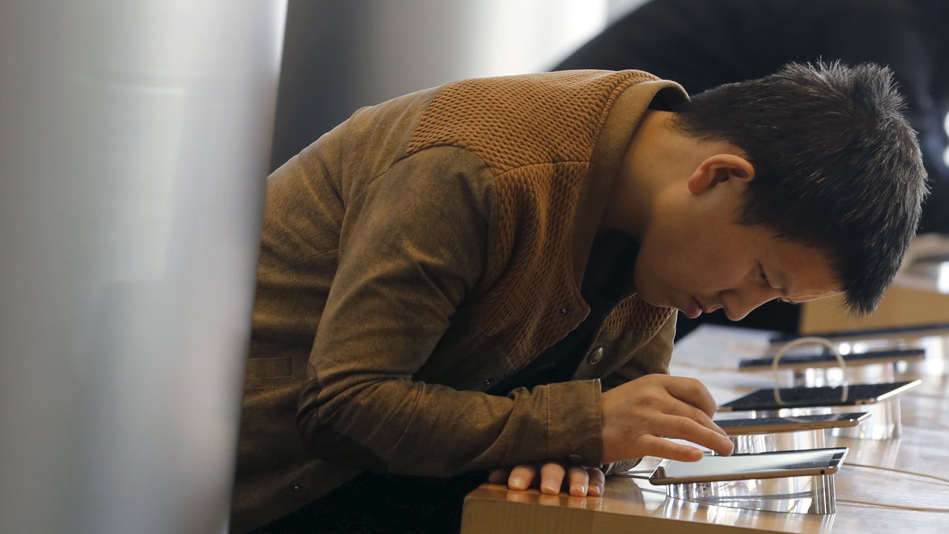 A man tries Apple's iPhone 6 at an Apple store in Beijing, November 2, 2015. (REUTERS/Kim Kyung-Hoon)