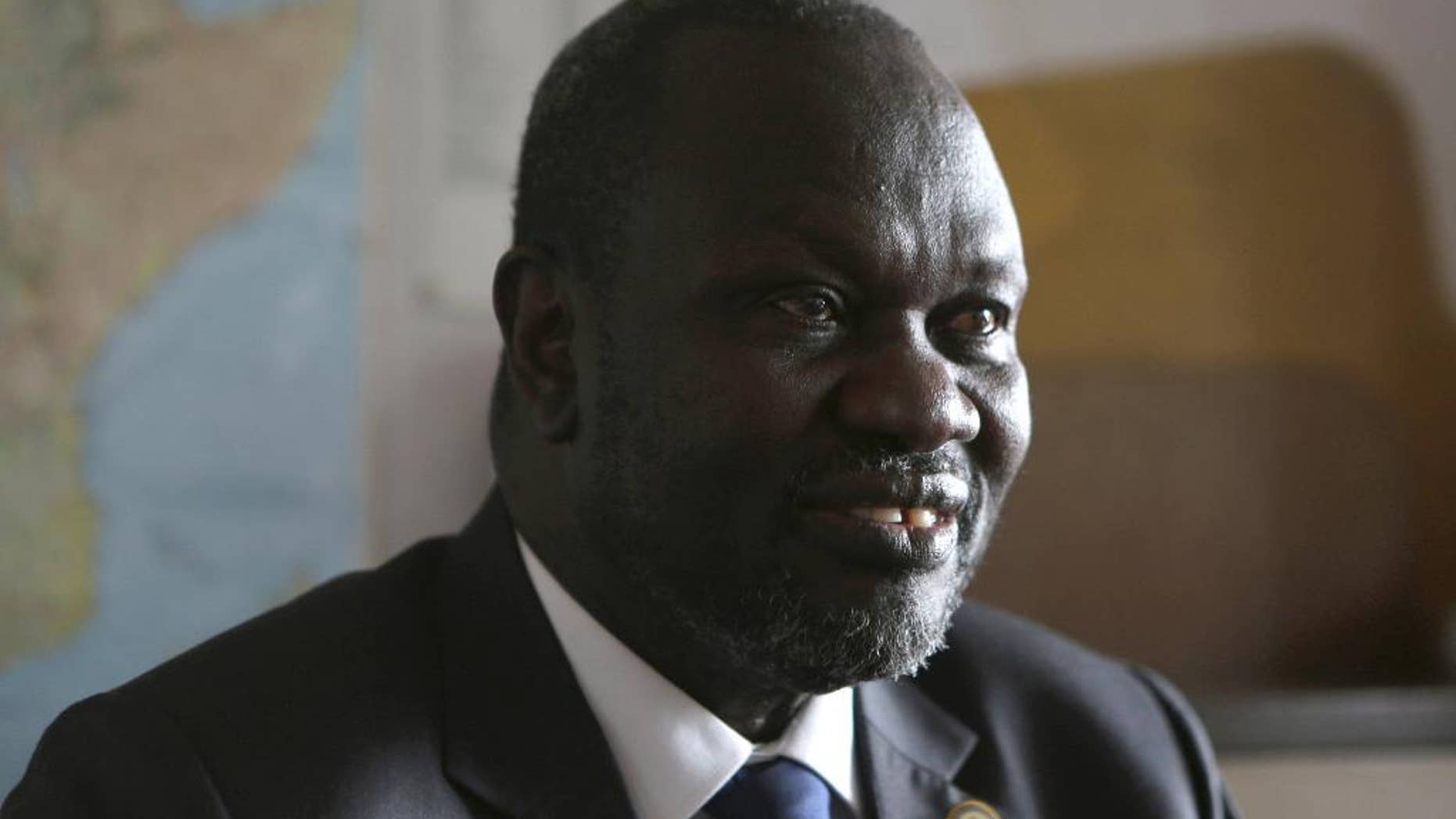 FILE - In this Thursday, Oct. 20, 2016 file photo, South Sudan rebel leader Riek Machar speaks in an interview with The Associated Press in Johannesburg. Riek Machar told The Associated Press in a phone interview on Saturday Dec. 17, 2016, he cannot leave his home in South Africa without first informing South African authorities. (AP Photo/Denis Farrell, File)