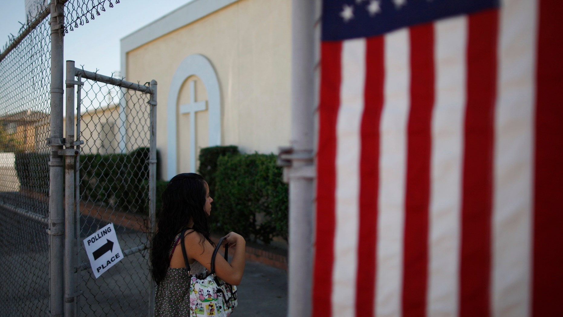 LOS ANGELES, CA - NOVEMBER 6: A woman enters a polling place in the heavily Latino East L.A. area during the U.S. presidential election on November 6, 2012 in Los Angeles, California. The election will decide whether Democrat Barack Obama serves a second term as president of the United States or is replaced by Republican rival, former Massachusetts Gov. Mitt Romney. (Photo by David McNew/Getty Images)