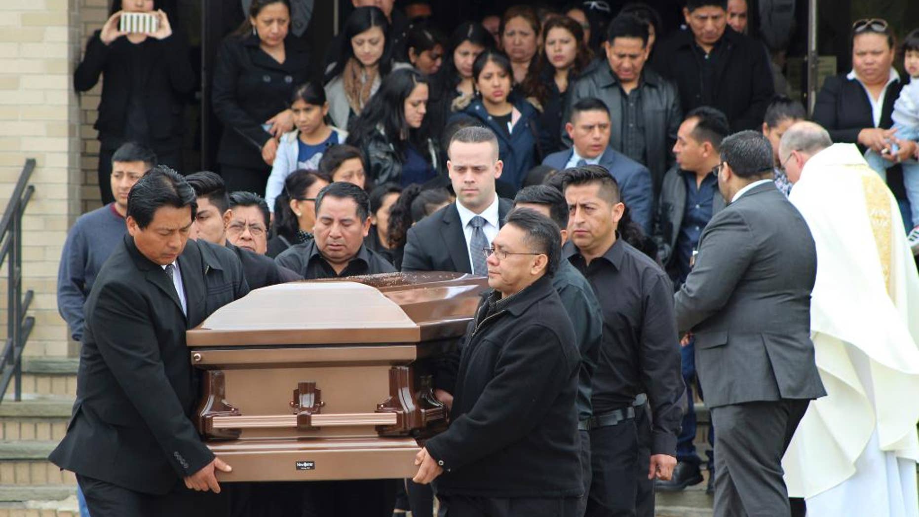 FILE - In this April 19, 2017 file photo, the casket of Justin Llivicura is carried from St. Joseph the Worker Church after Llivicura's funeral in East Patchogue, N.Y. Llivicura, 16, was one of four young men found slain in a suspected MS-13 gang killing in a park in Central Islip, N.Y., on April 12. The gang has been blamed for the deaths of nearly a dozen young people in blue-collar Brentwood and Central Islip since the school year began. (AP Photo/Frank Eltman, File)