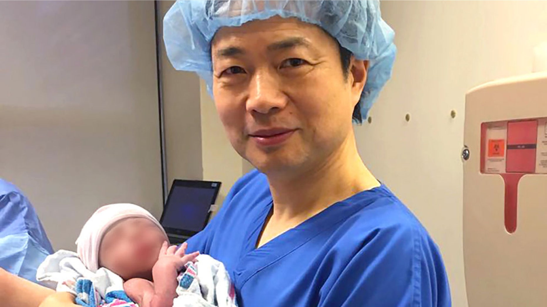 In this undated image, Dr. John Zhang holds a baby believed to be the first-ever born using DNA from three people