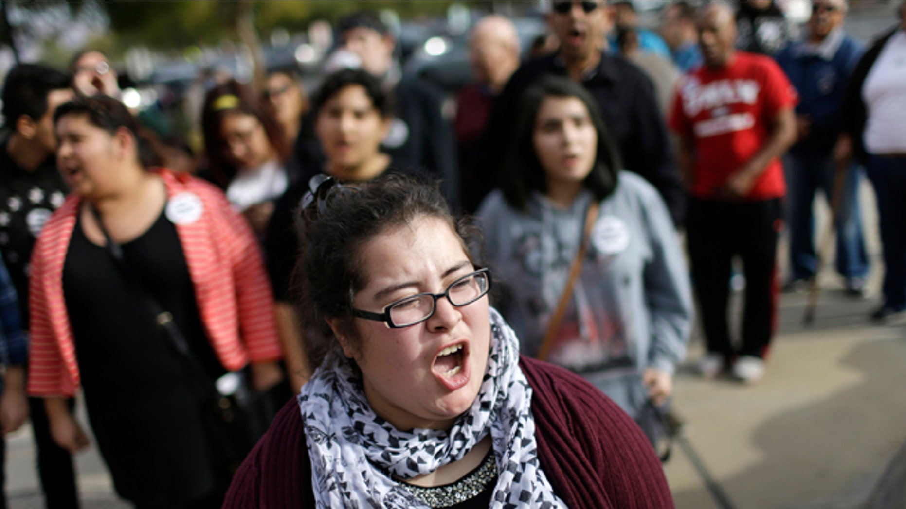 Dulce Valencia and others chant during a protest Wednesday, Jan. 28, 2015, in Las Vegas. A group was demanding that Nevada Attorney General Adam Laxalt drop a lawsuit against President Barack Obama's immigration action. (AP Photo/John Locher)