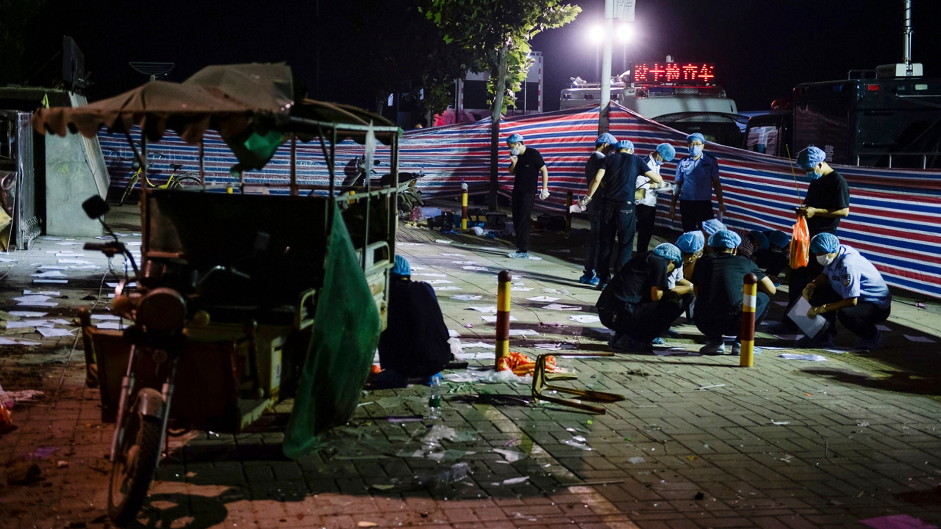 In this photo released by China's Xinhua News Agency, investigators work early Friday, June 16, 2017, at the scene of an explosion outside a kindergarten in Fengxian County in eastern China's Jiangsu Province.