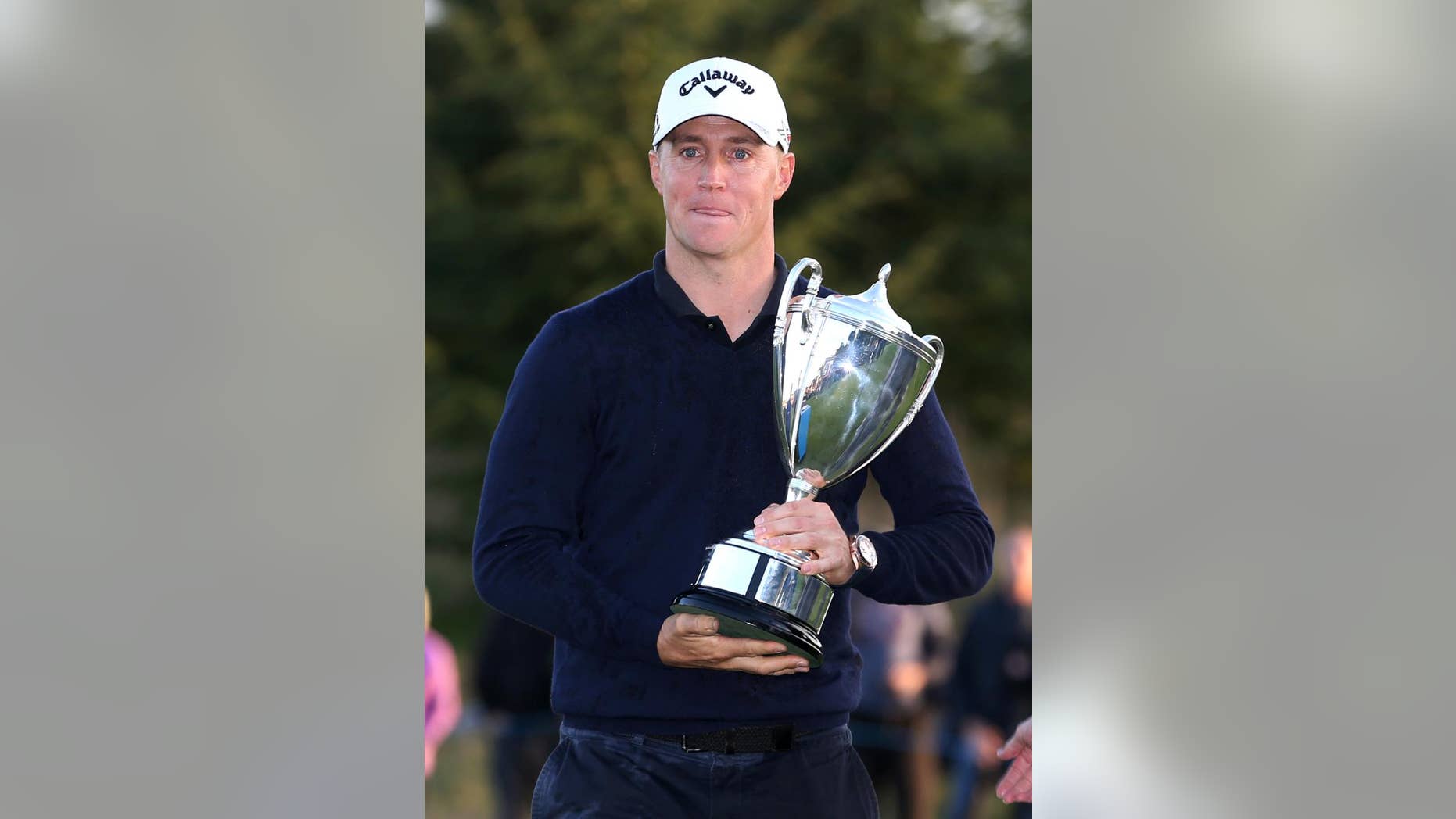 Sweden's Alex Noren celebrates with the trophy after winning The British Masters golf tournament at The Grove, Chandler's Cross, England, Sunday Oct. 16, 2016. (Steven Paston / PA via AP)
