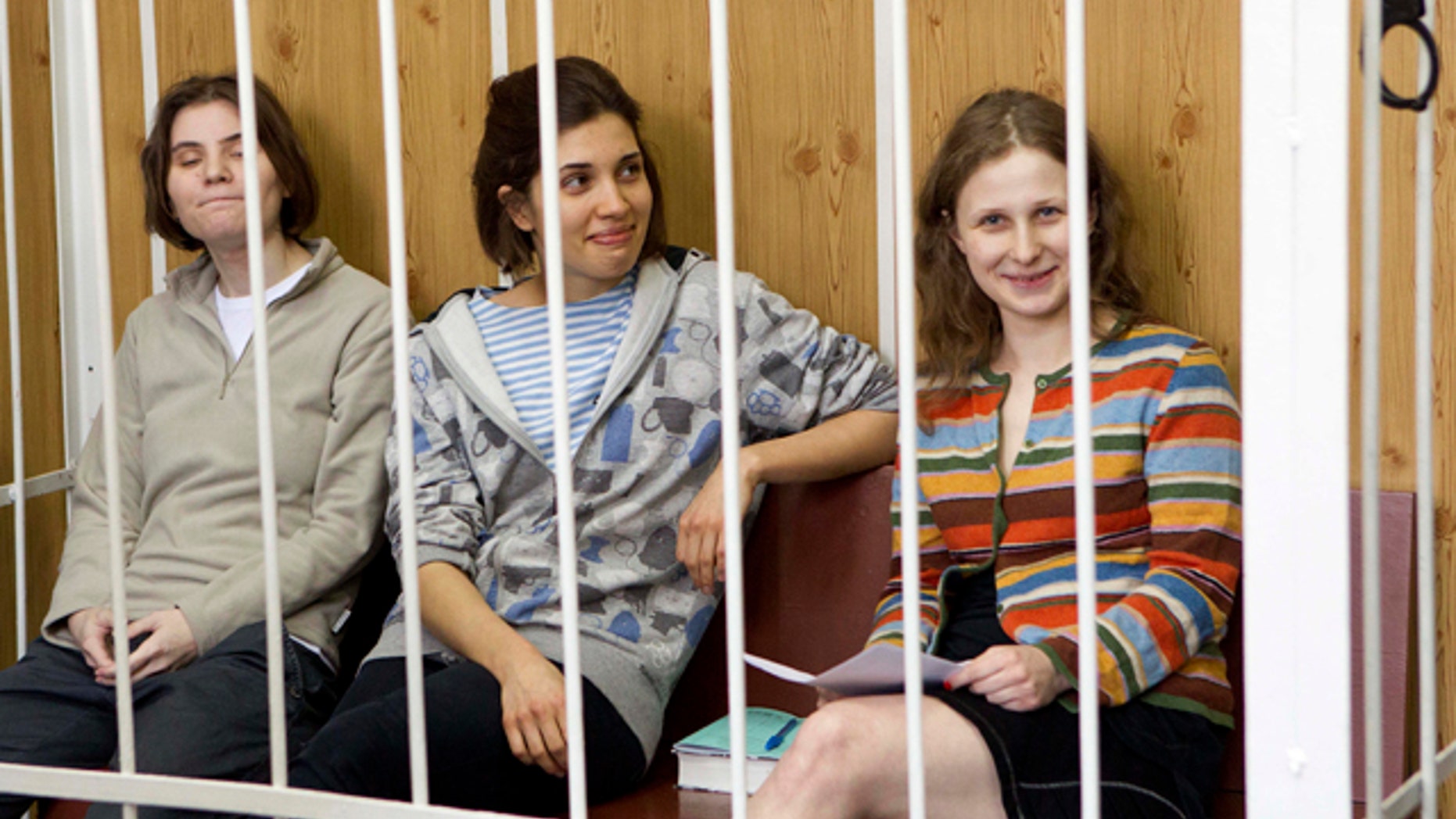 July 20, 2012: From left, Yekaterina Samutsevich, Nadezhda Tolokonnikova, Maria Alekhina, members of feminist punk group Pussy Riot sit behind bars at a court room in Moscow, Russia.