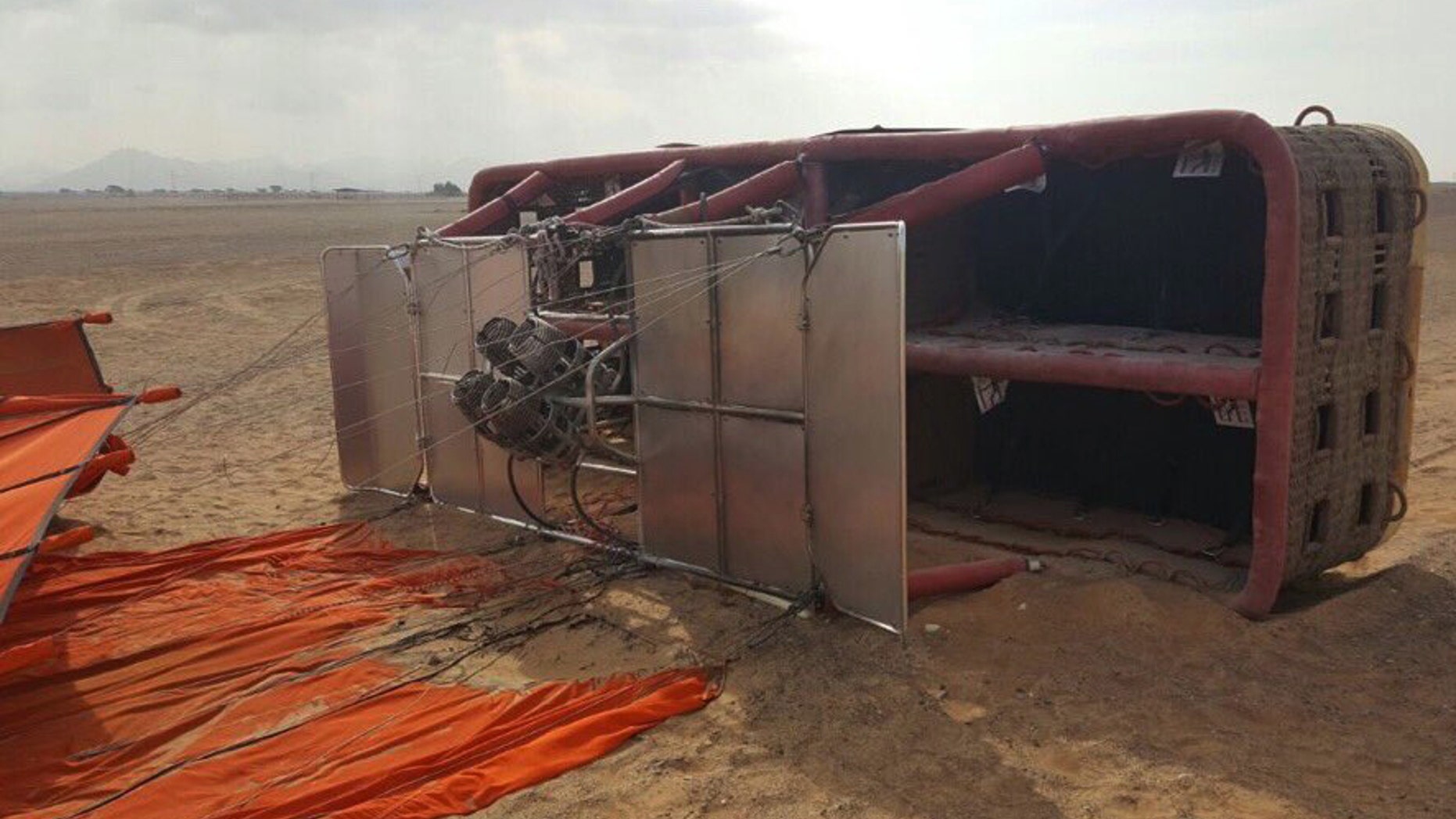 This Saturday, Jan. 14, 2017, released by Sharjah police, and made available today, shows a balloon that was carrying European and Asian tourists after it struck the ground as it flew over the desert near the small town of al-Madam, United Arab Emirates. Investigators in the UAE are looking into what caused a hot-air balloon to abruptly drop from the sky, injuring six tourists onboard. (Sharjah Police via AP)