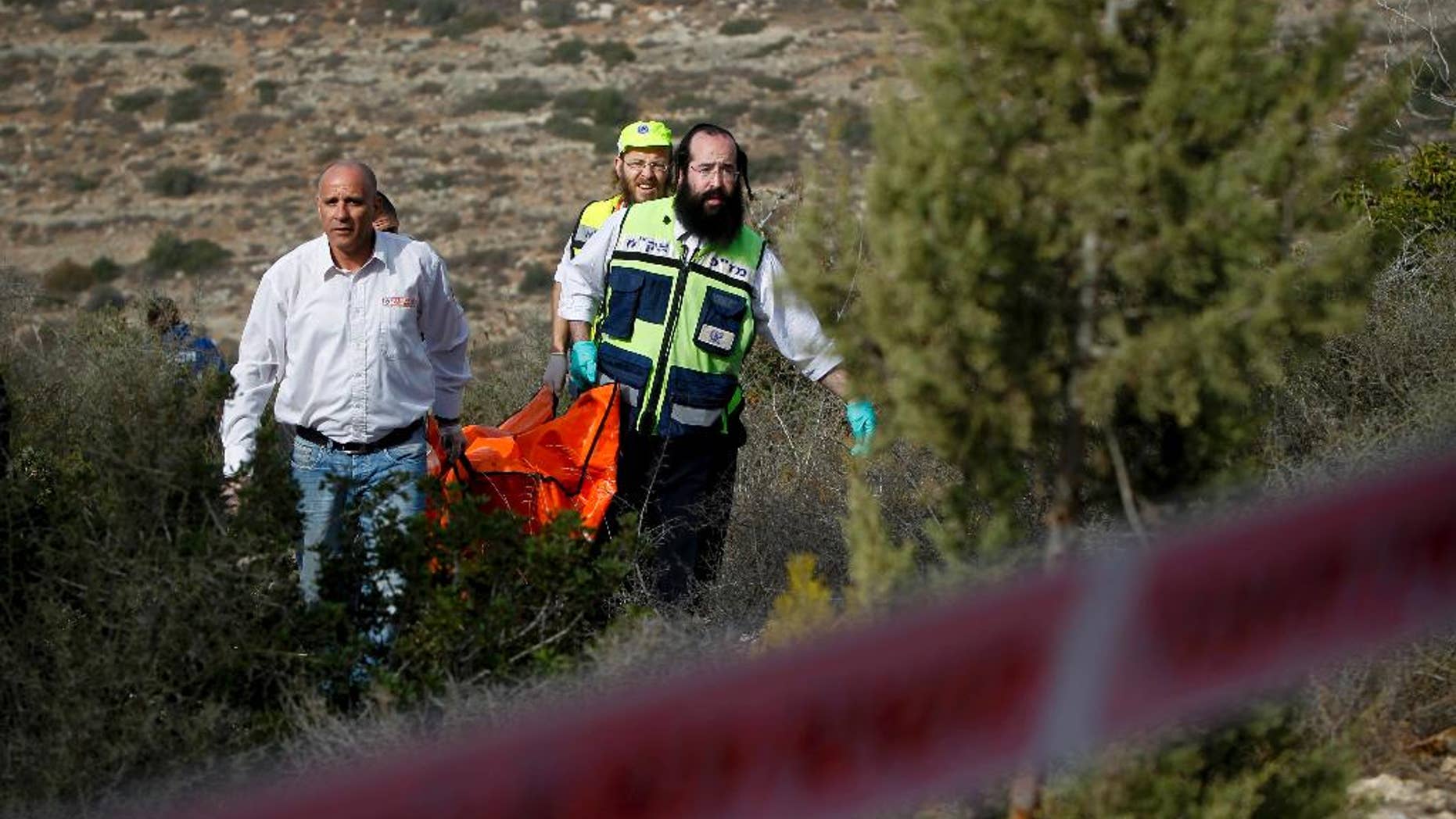 FILE - In this Dec. 19, 2010 file photo, Israeli rescue workers carry the body of U.S. tourist Kristine Luken after she was found in a wooded area near the village of Mata, outside Jerusalem. Two Palestinian men convicted in Israel of murdering Luken who was hiking near an Israeli archaeological site could face charges in the U.S. if they're ever released from an Israeli prison. (AP Photo/Tara Todras-Whitehill, File)