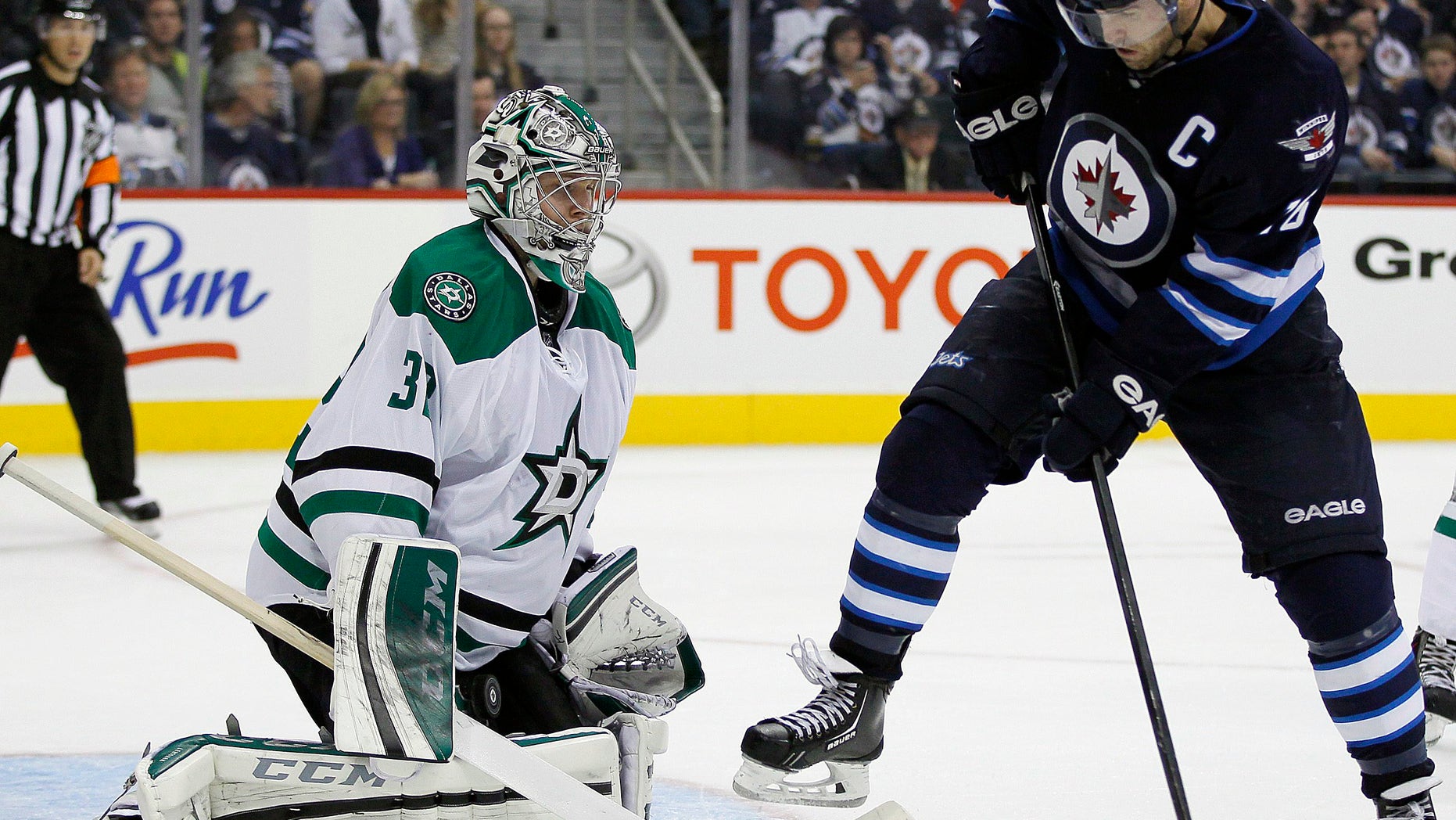 Winnipeg Jets' Andrew Ladd's (16) deflection is stopped by Dallas Stars' goaltender Kari Lehtonen (32) during second-period NHL hockey game action in Winnipeg, Manitoba, Friday, Oct. 11, 2013. (AP Photo/The Canadian Press, John Woods)