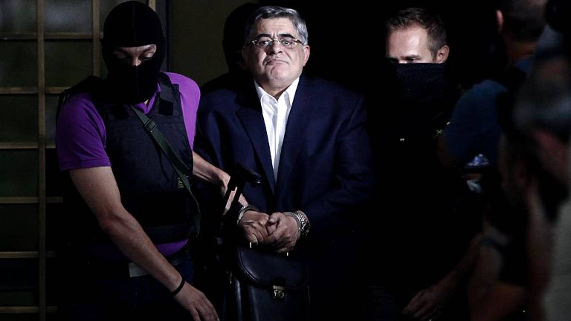 The leader of Greece's Golden Dawn party Nikos Michaloliakos is escorted by masked police officers in Athens, on September 28, 2013
