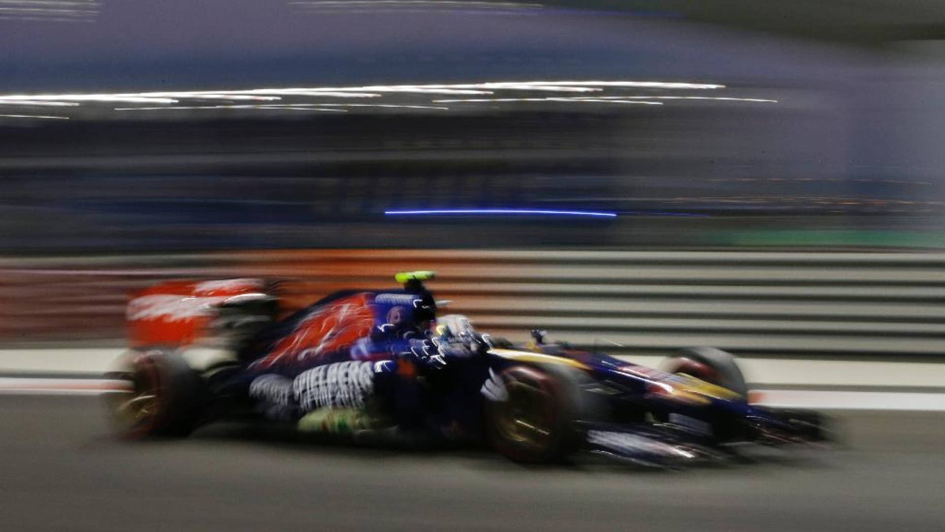 Toro Rosso driver Daniil Kvyat of Russia steers his car during the qualifying session ahead of the Abu Dhabi Formula One Grand Prix at the Yas Marina racetrack in Abu Dhabi, United Arab Emirates, Saturday, Nov. 22, 2014. The Emirates Formula One Grand Prix will take place on Sunday. (AP Photo/Hassan Ammar)