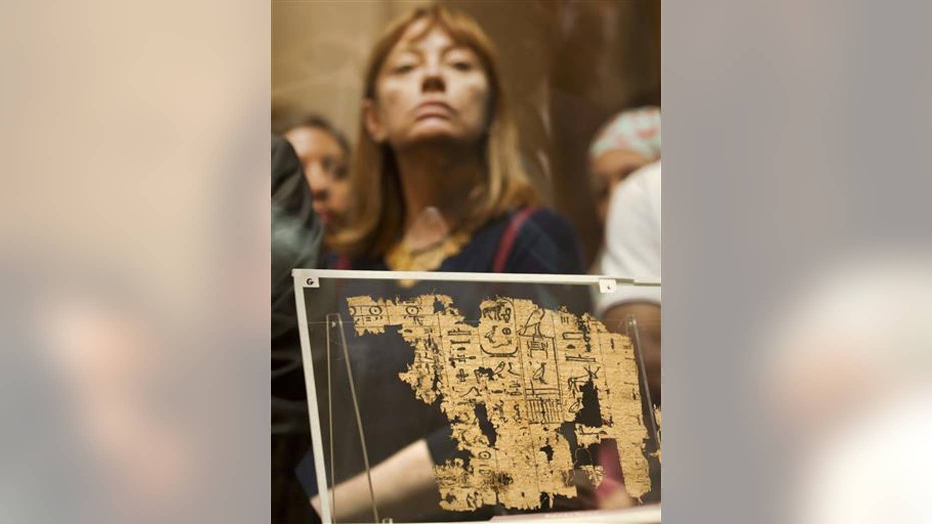 A visitor looks at one of the oldest papyri in the history of Egyptian writing among the collection of King Khufu papyri discovered at Wadi El-Jarf port, as it is on display for the first time at the Egyptian museum in Cairo, Egypt, Thursday, July 14, 2016.