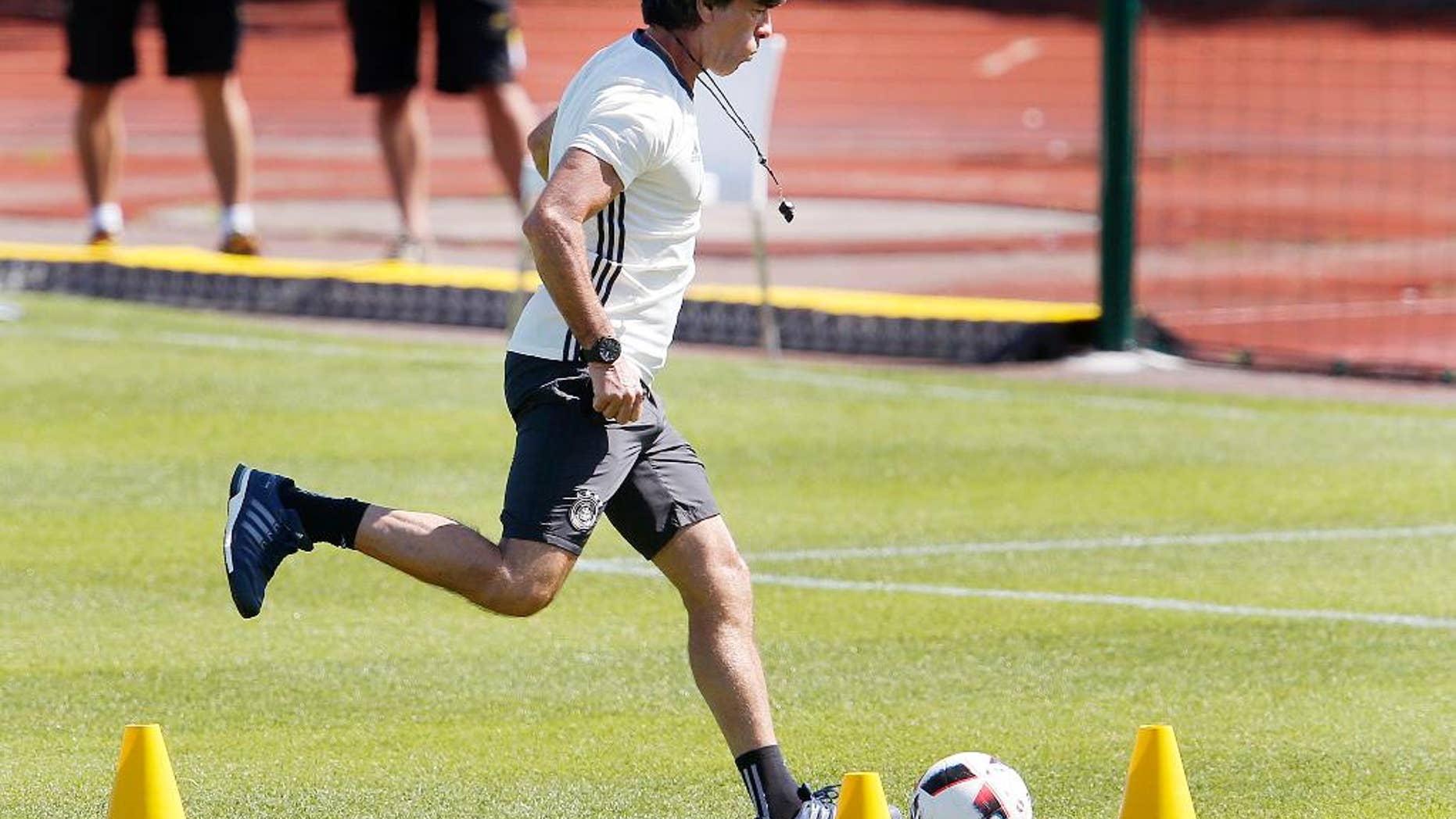 Coach Joachim Loew kicks the ball during the last training session of the German national football team at their base camp in Evian-Les-Bains, France, Wednesday, July 6, 2016. Germany will face France in a Euro 2016 semifinal soccer match in Marseille on Thursday, July 7, 2016 (AP Photo/Michael Probst)