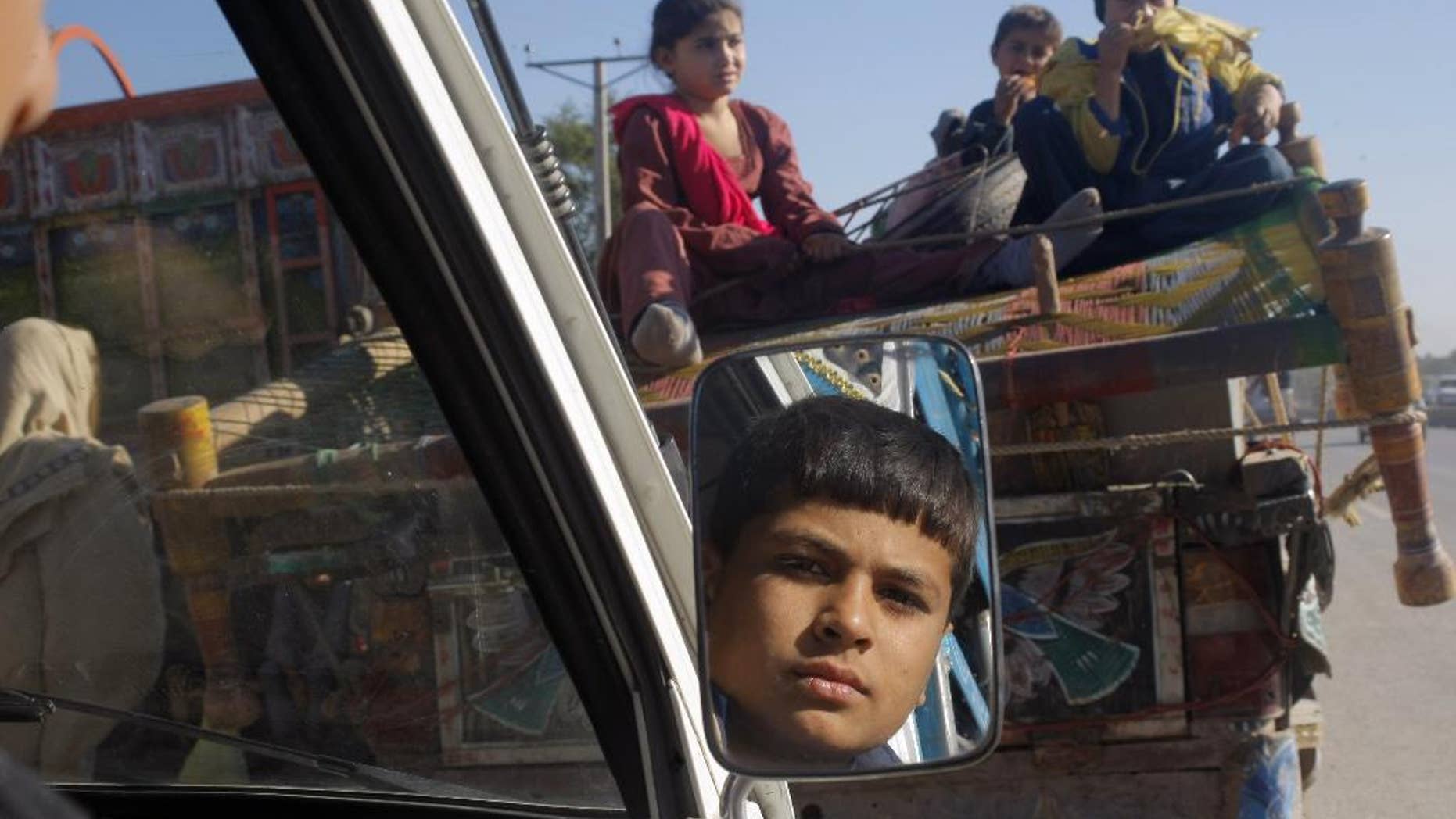 Pakistani families fleeing fighting between security forces and militants in the neighboring Khyber tribal region arrive in Peshawar, Pakistan, Monday, Nov. 10, 2014. The Pakistani army is now regularly targeting militants' hideouts in Khyber, since fighters fled there from neighboring North Waziristan tribal region where it has been conducting a months long operation. (AP Photo/Mohammad Sajjad)
