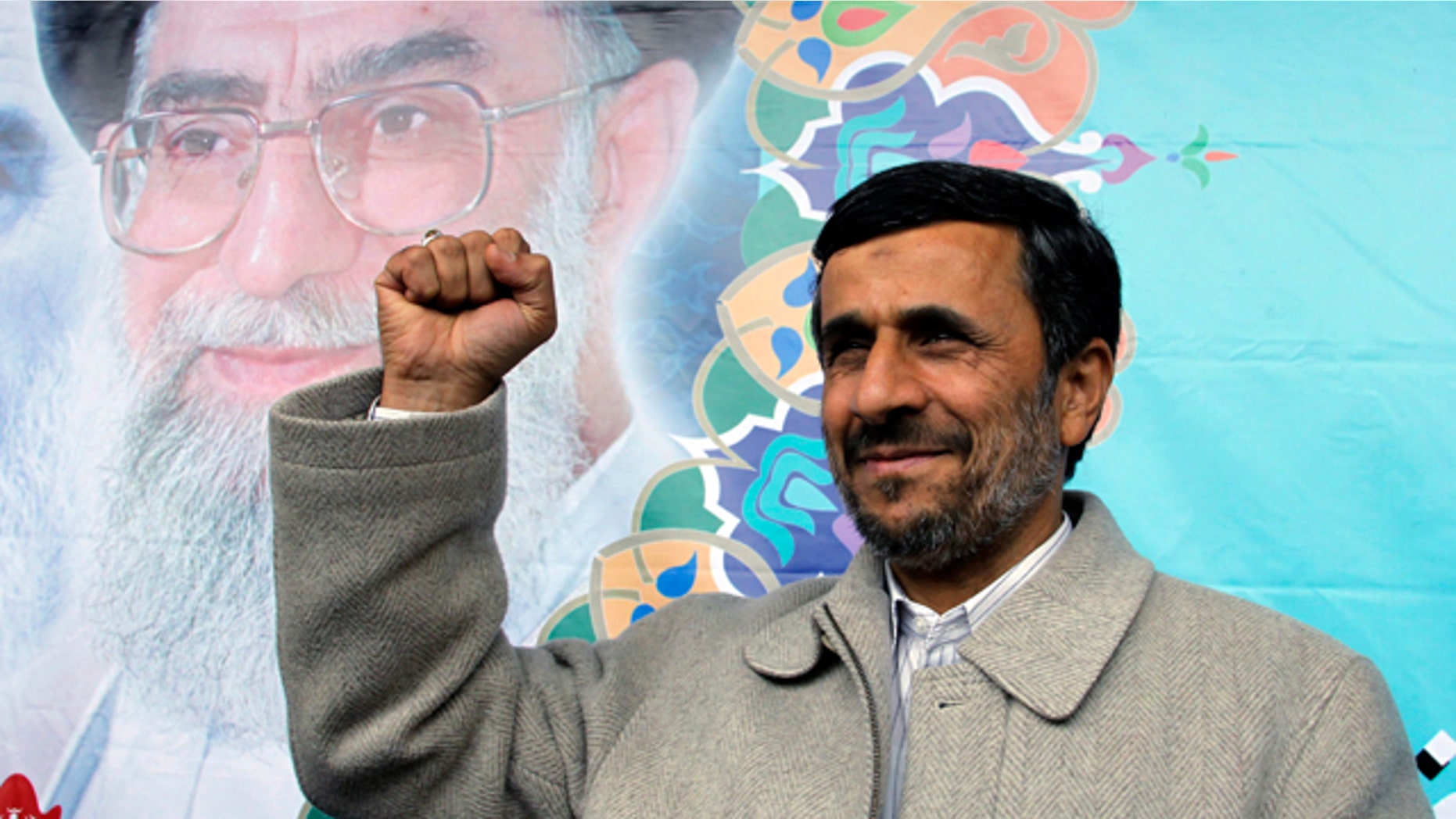 February 2011: Iranian President Mamoud Ahmadinejad, shown in this file photo pumping his fist, reportedly has been butting heads with Supreme Leader Ayatollah Ali Khamenei, in background.